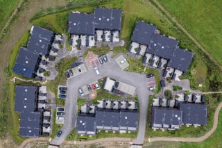 Die Reihenhäuser von Juul Frost Architekten liegen am Rande eines ehemaligen Flugplatzes, der heute als Naturschutzgebiet gilt.