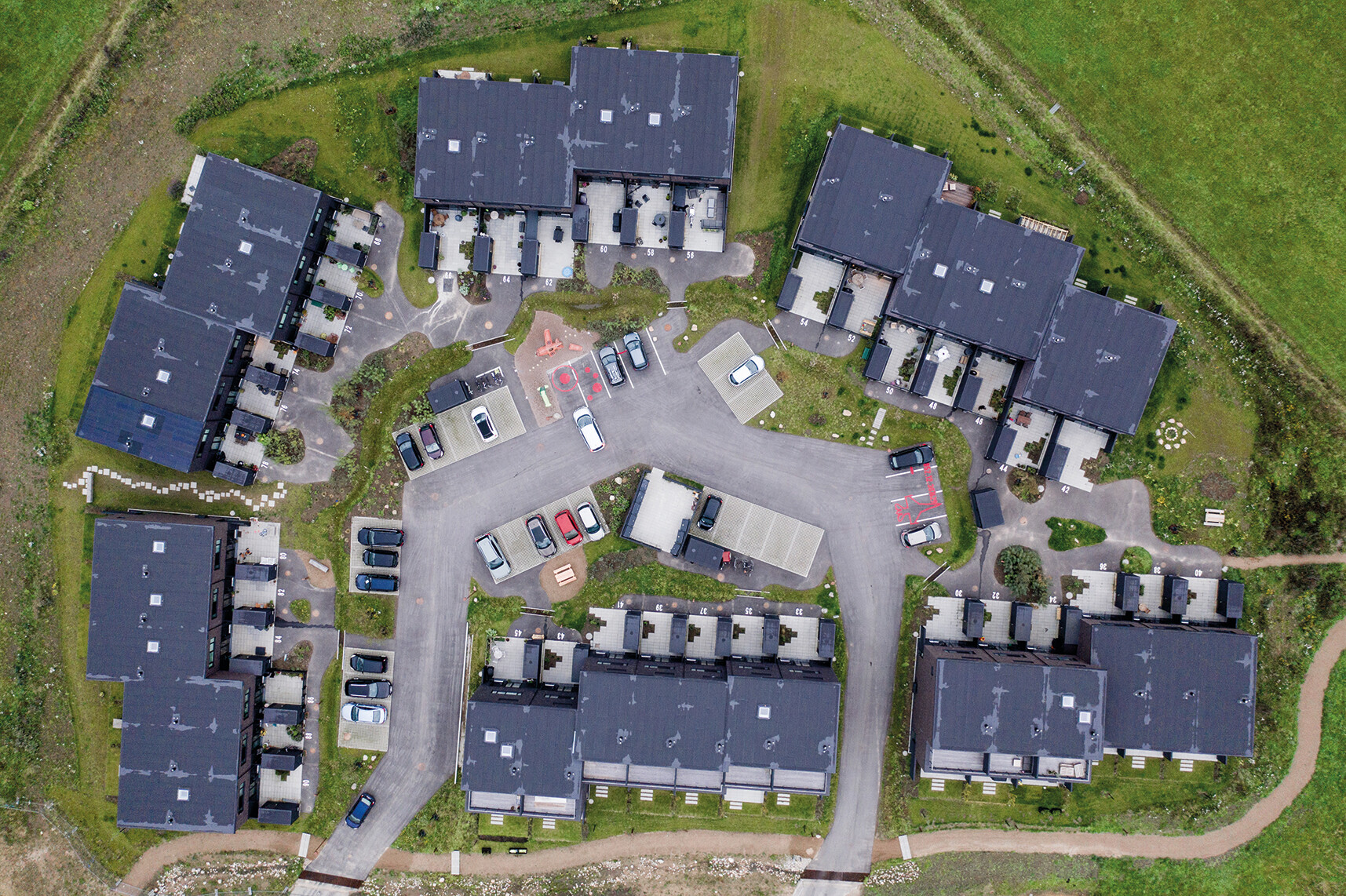 Cluster aus Häusern sammeln sich um Innenhöfe mit unterschiedlichen Bepflanzungen.