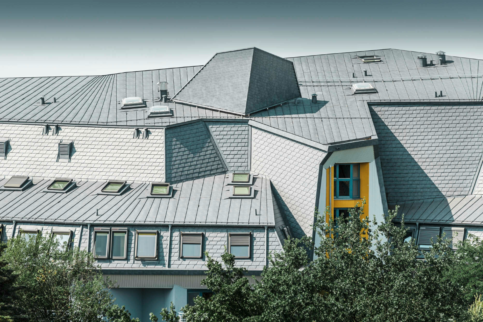 Die verwinkelten Dachflächen hat er mit unterschiedlichen Aluminium-Dachschindeln von Prefa neu eingedeckt und gestaltet.