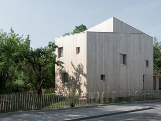 Ein Ensemble aus zwei unterschiedlich hohen, versetzt angeordneten Gebäuden und einer Garage vereinen unterschiedliche Nutzungen.