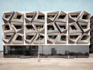 Der von Studio Ardete geplante Büro- und Gewerbebau zeichnet sich durch seine Fassade aus, die von geometrisch komplex geformten Loggias und vorgeblendeten Scheiben aus Beton geprägt wird. 