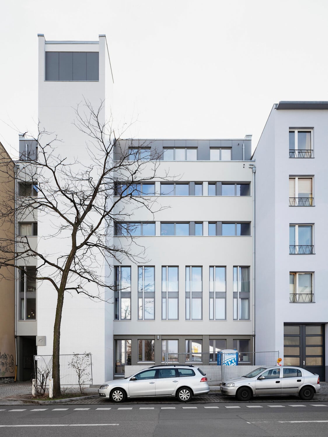 Der kantige weiße Turm weist auf die ursprünglich sakrale Nutzung hin und ist dem heutigen Wohngebäude vorangestellt.
