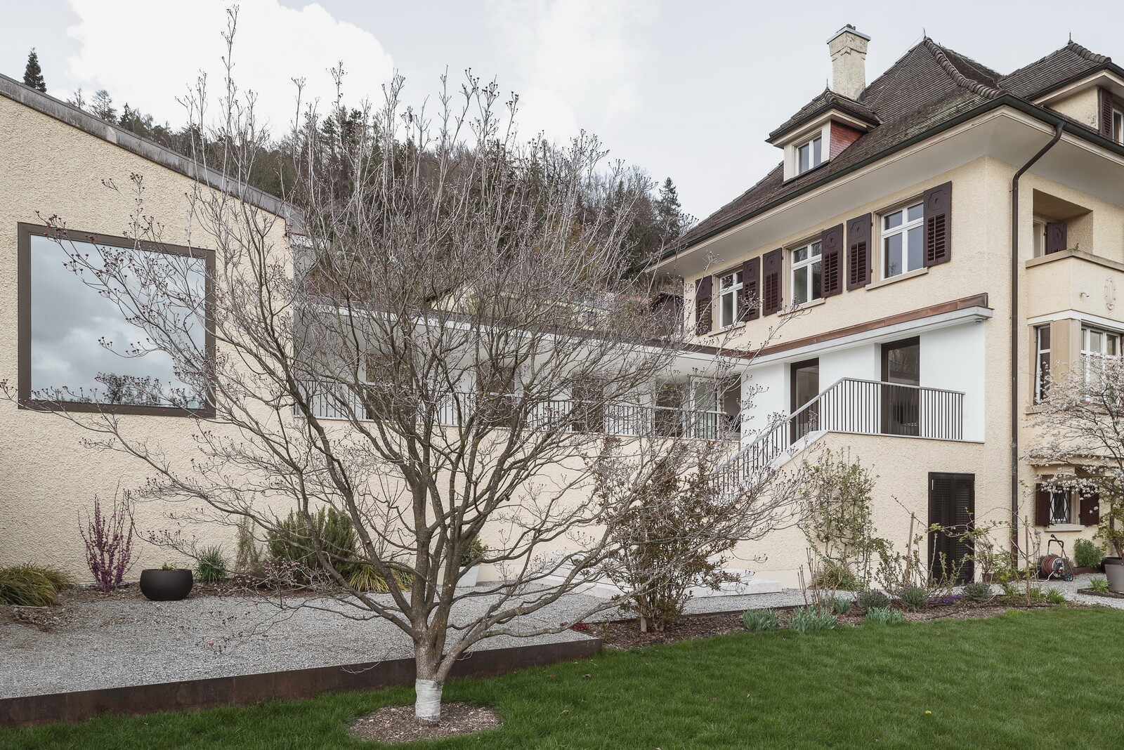 Wo sich zuvor ein verwachsener Garten befand, erweitert jetzt eine großzügige Terrasse zwischen Bestand und Erweiterungsbau (links im Bild) mit Blick über das Tal den Wohnraum nach außen.