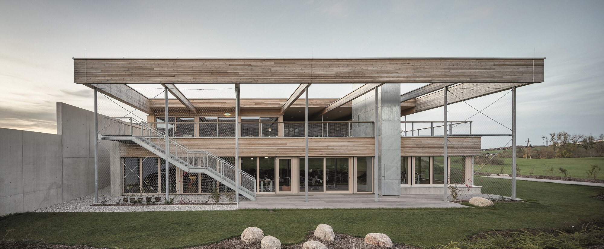 Die Fassade besteht aus Lärchenholz. Holzoberflächen dominieren, für wenige tragende Elemente und erdberührte Bauteile kam Beton zum Einsatz.