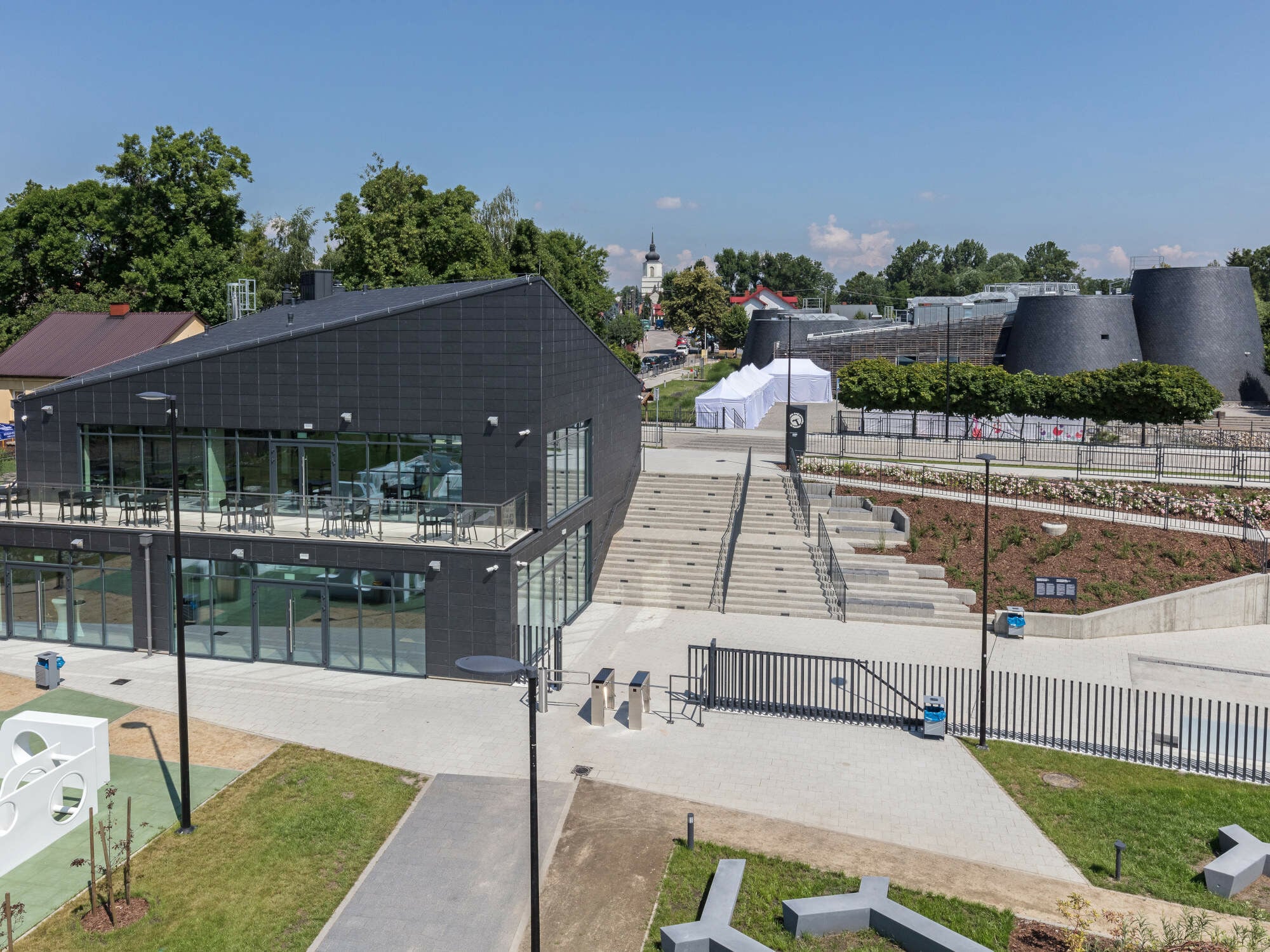 Europäisches Märchenzentrum im polnischen Pacanów, geplant von der Stettiner Domino grupa architektoniczna: Im Vordergrund das neue Eingangsgebäude (2021), im Hintergrund das festungsähnliche Ausstellungshaus (2010)