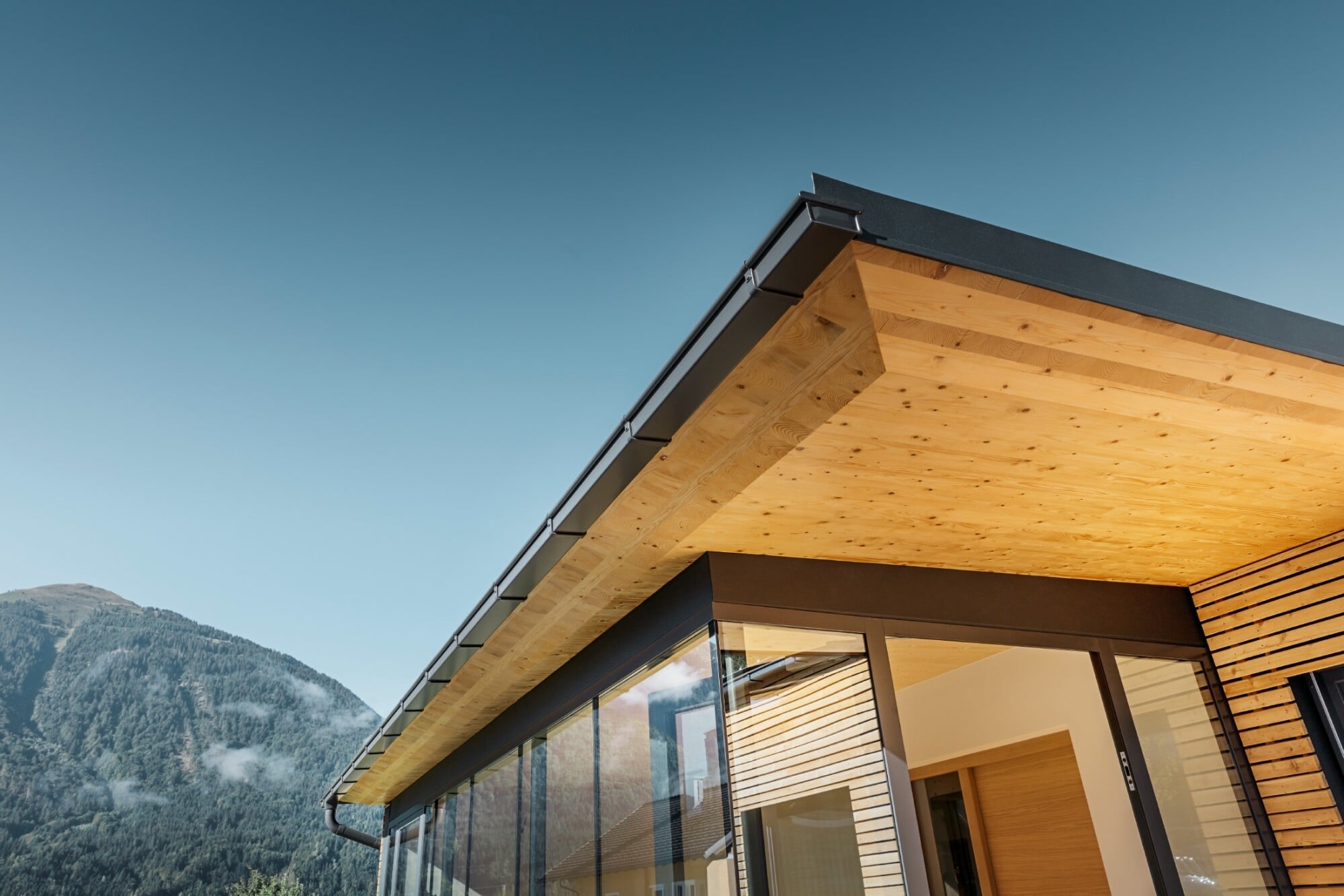 Der Holzbau besteht aus naturbelassener Lärche und das Dach schließt mit einer eleganten Schrägkante ab.