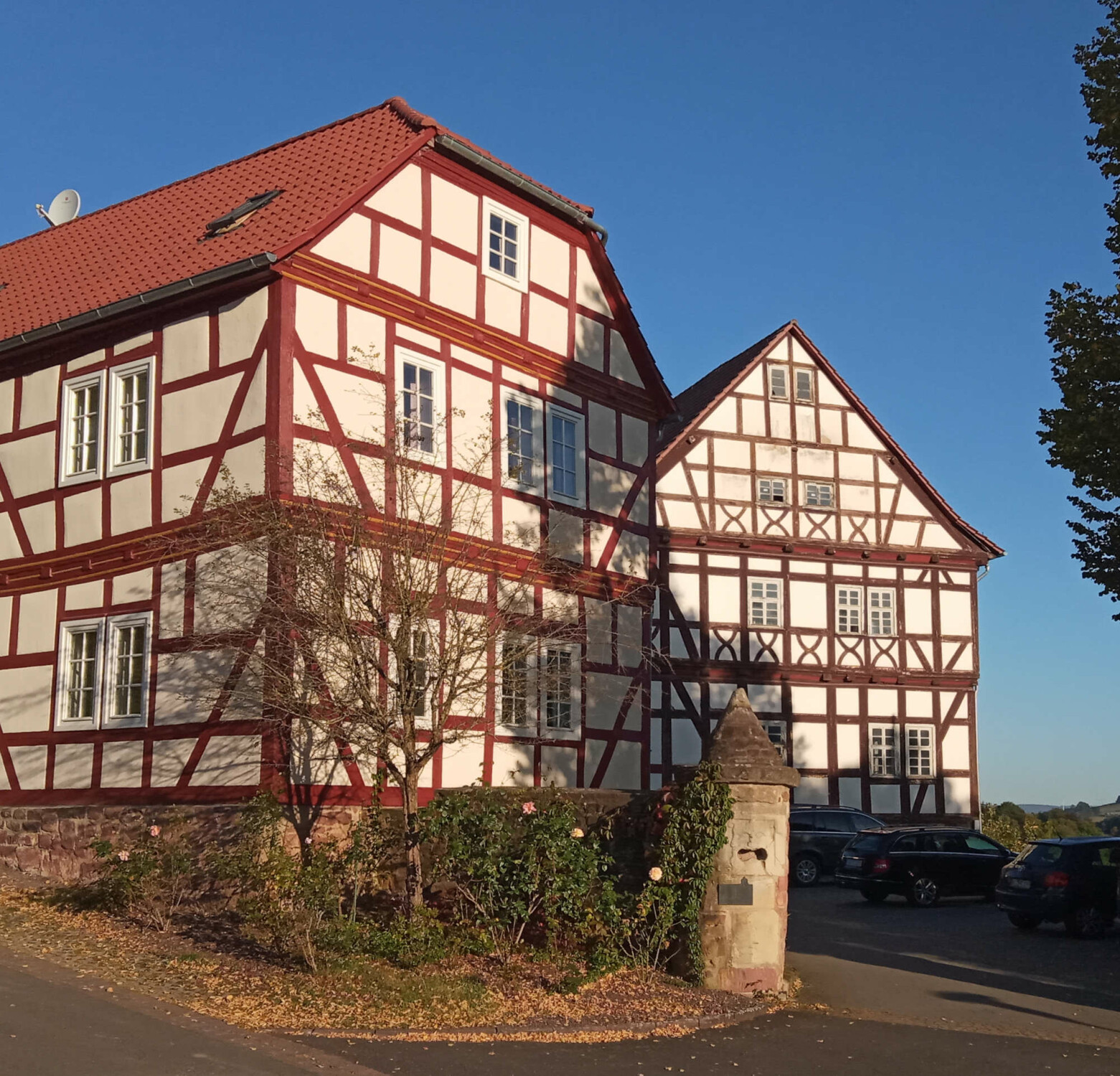 Saniertes Fachwerkensemble auf Bruchsteinsockel im hessischen Buchenau (Gemeinde Eiterfeld): Rechts das sogenannte Generalshaus mit Wurzeln im späten 16. Jahrhundert, links eine Erweiterung mit Mansarddach aus dem 18. Jahrhundert. In der Fassade des älteren Hauses sind Andreaskreuze erkennbar.