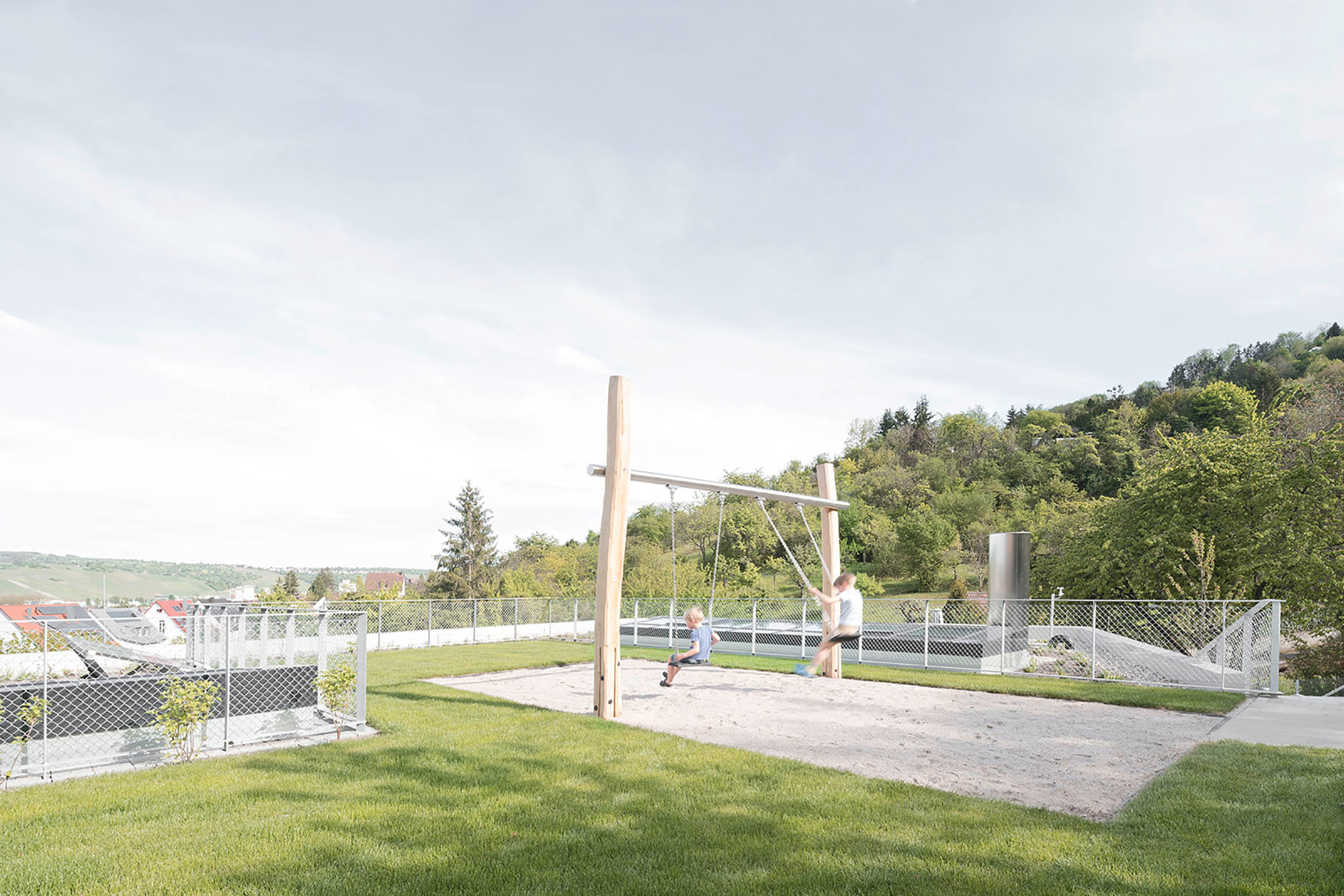 Die topographische Herausforderung lösten die Architekturschaffenden mit einem zweigeschossig terrassierten Baukörper, der hangseitig ins Erdreich geschoben ist.