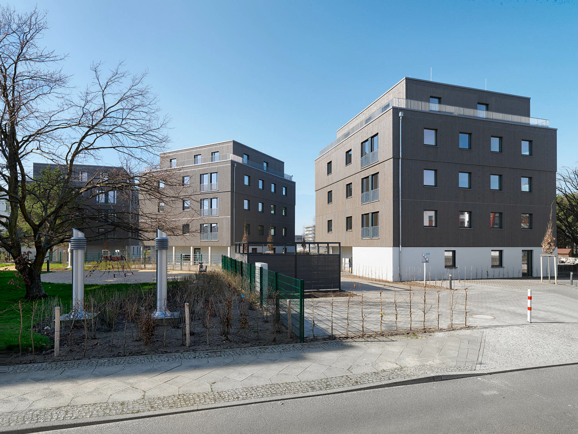 In Berlin Adlershof sind nach Plänen des Architekturbüros Kaden+Lager (jetzt LAGERSCHWERTFEGER und Kaden+) drei Holzhybridhäuser mit 42 Wohnungen entstanden. 