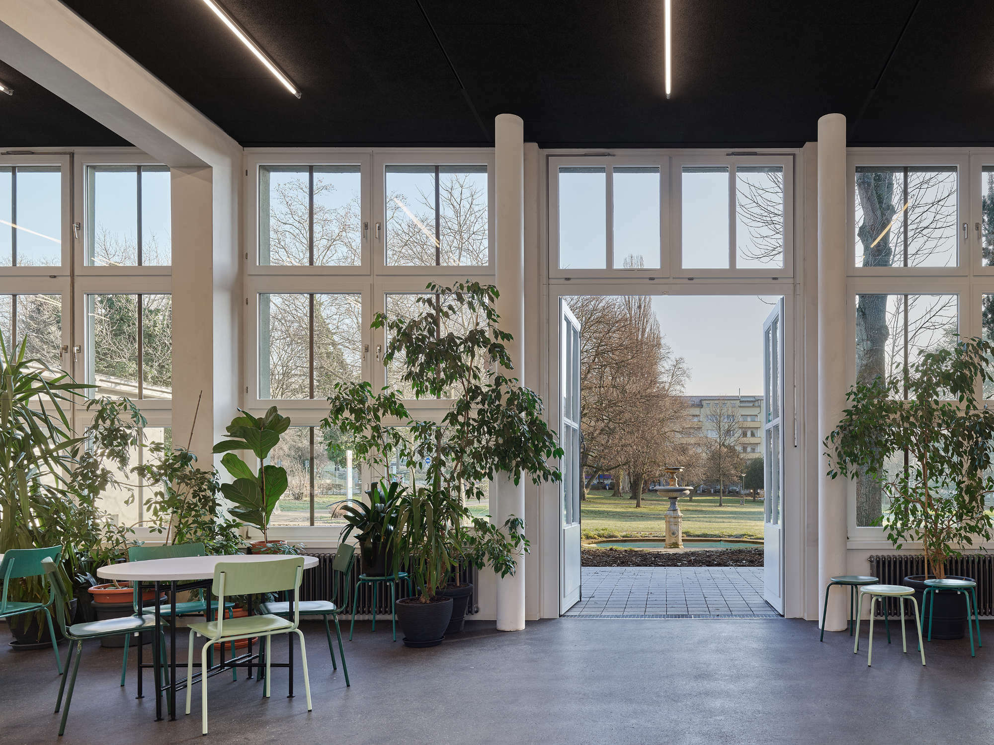 Blick vom Veranstaltungssaal mit neuen weißen Stahlstützen in den Benckiserpark