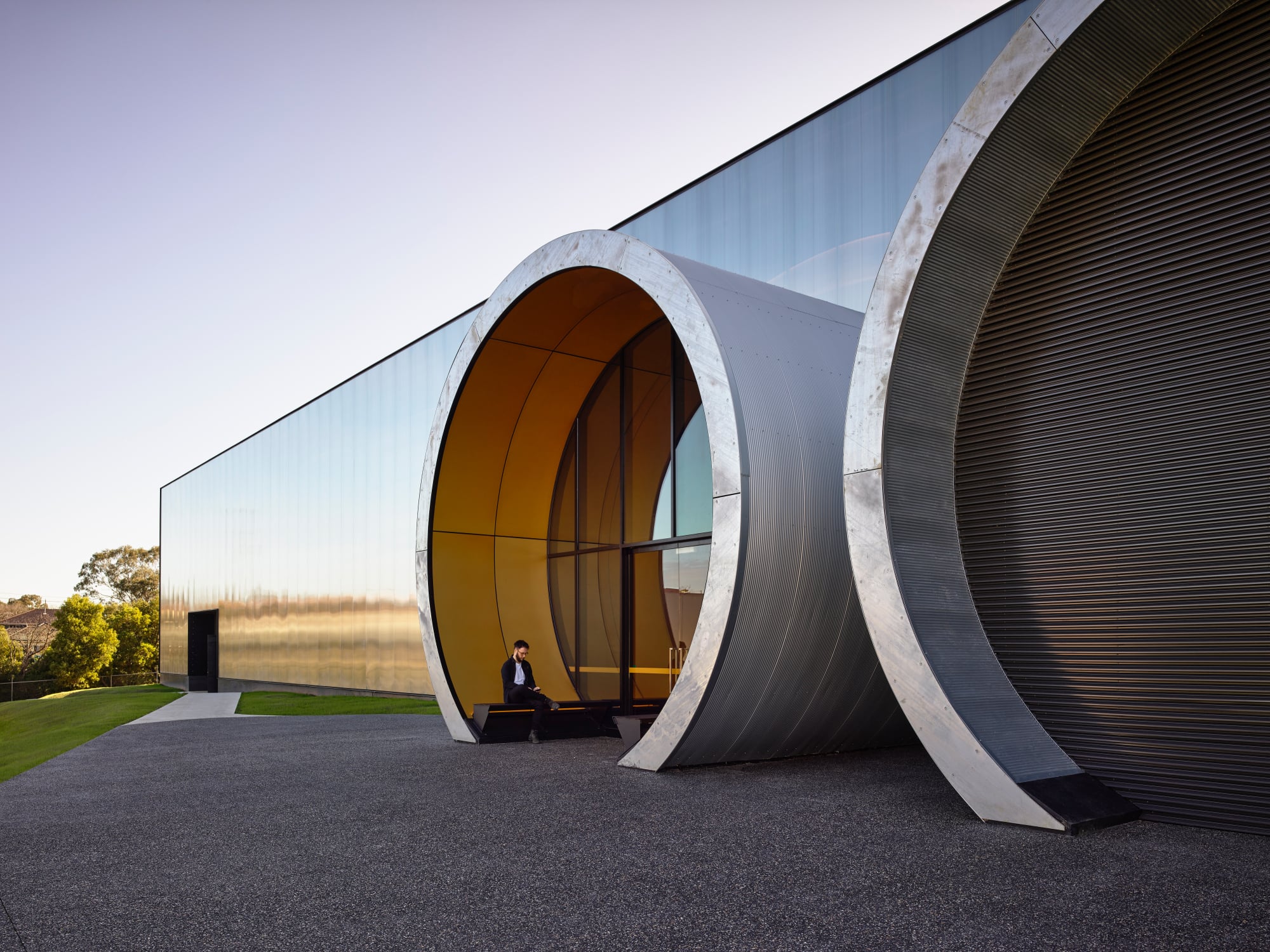 Auffälligstes Merkmal sind die zwei massiven Tunnelteile, die einige Meter aus der glatten, transluzenten Fassade herausstechen. 