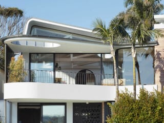 Alles auf Aussicht: Im Obergeschoss des Wohnhauses für eine Familie kragt der Balkon wellenförmig aus. 