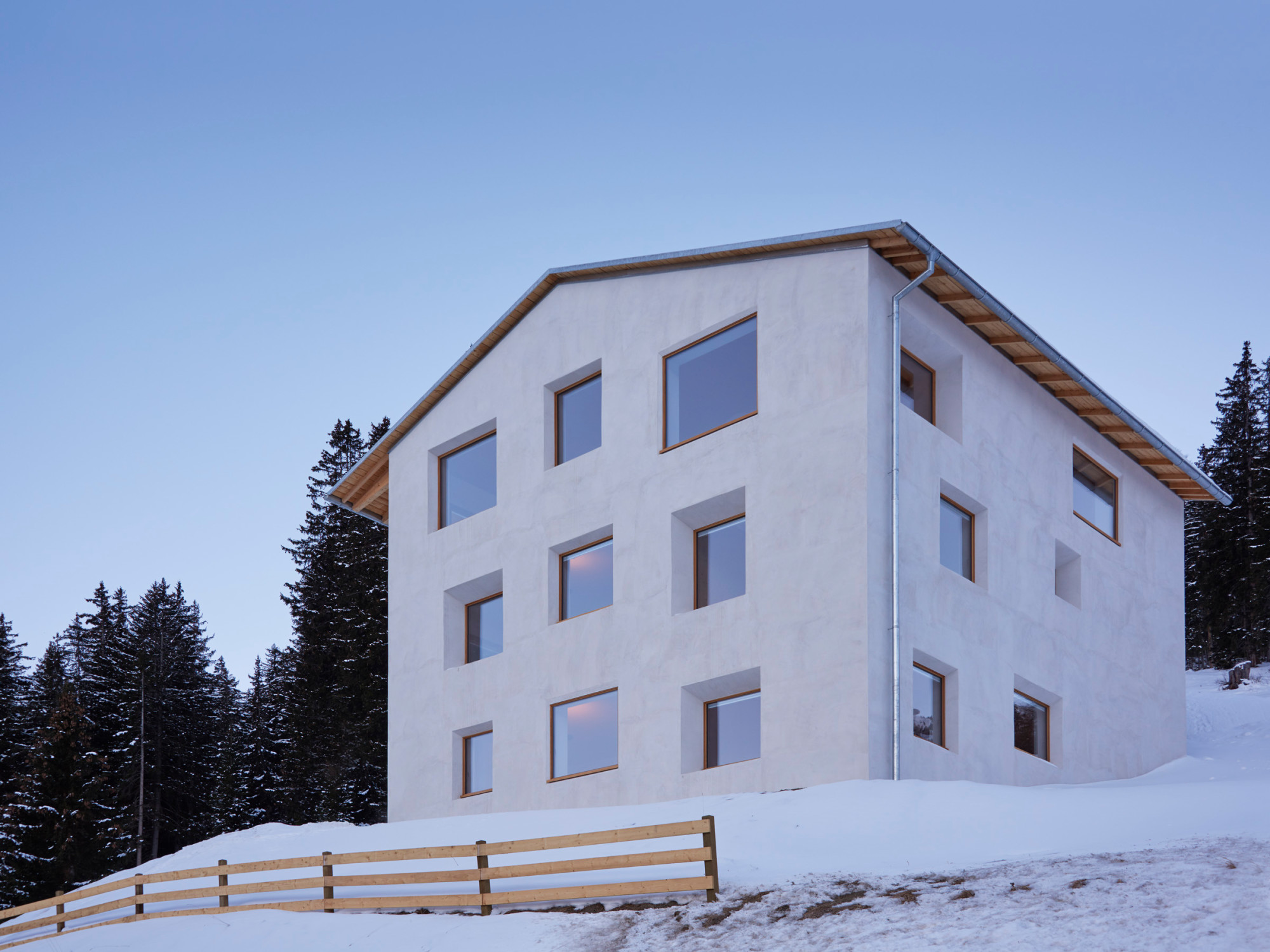 Verschiedene Fenstergrößen und unterschiedlich tief in das Mauerwerk gesetzte Rahmen beleben das schlichte Außenbild und setzen subtile Akzente.