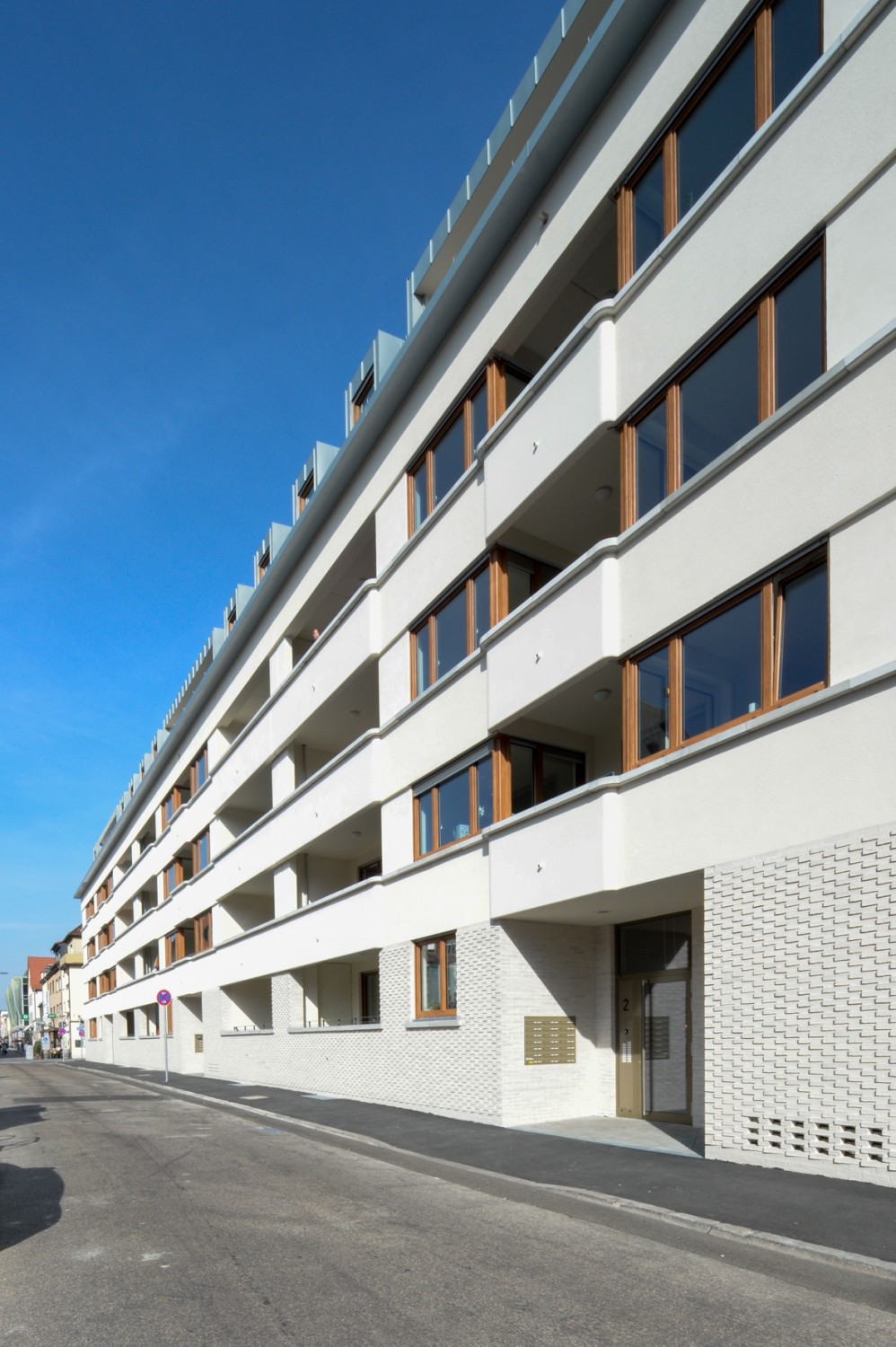 Die straßenseitige Fassade ist geprägt durch helle Klinker im Erdgeschoss, verputzte Flächen der Obergeschosse und eine horizontale Gliederung.