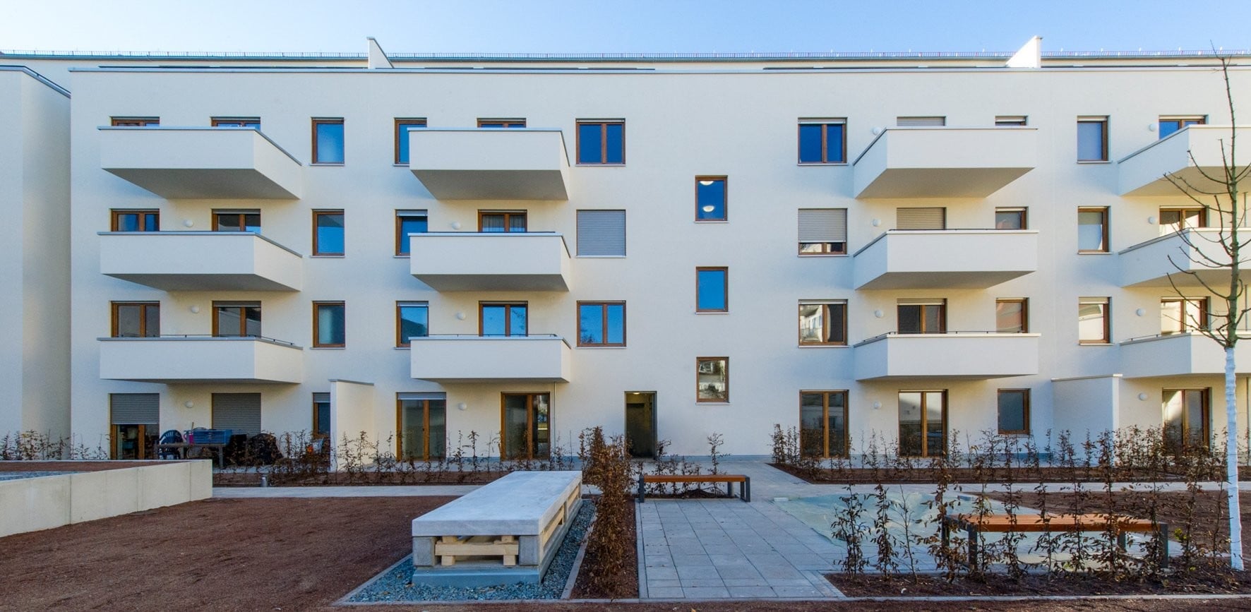 Der viergeschossige Neubau mit weiteren Wohnungen im Dachgeschoss ist an den Proportionen der angrenzenden Blockrandbebauung orientiert und bildet im Osten mit dieser einen Hof aus. 