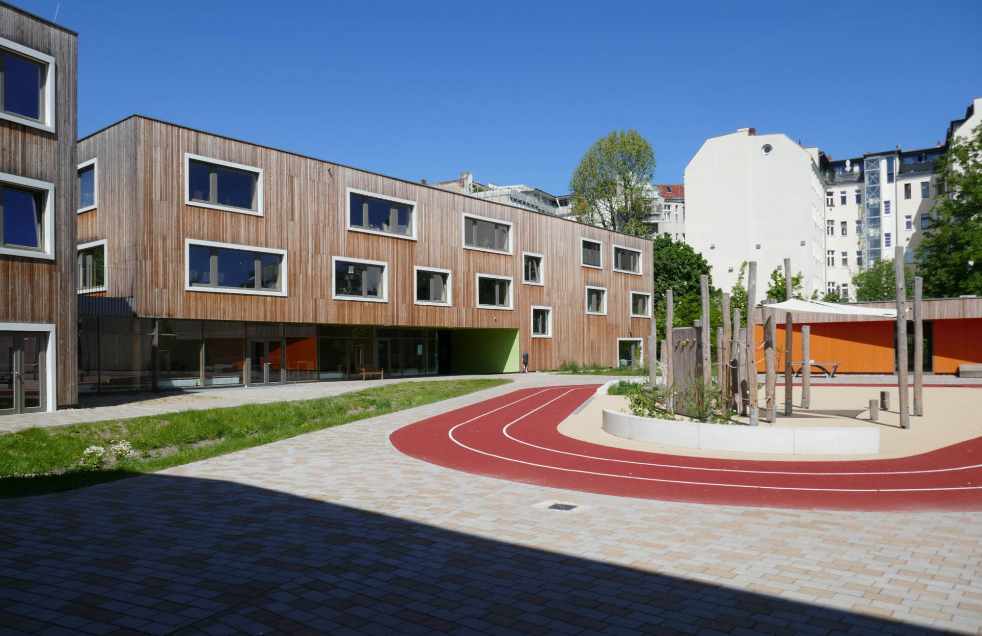 Zum Tragwerk gehört auch ein Skelett aus Brettschichtholzstützen und -riegeln mit Holzrahmenbauausfachung in der Fassade, bekleidet mit einer sägerauen Bretterschalung aus Lärchenholz.
