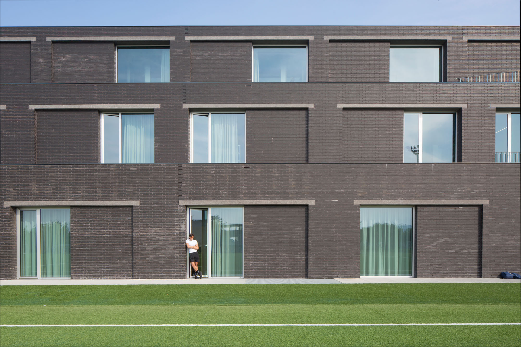 Die Fassade besteht aus schwarzroten Verblendern im Läuferverband und Stürzen aus poliertem Beton.