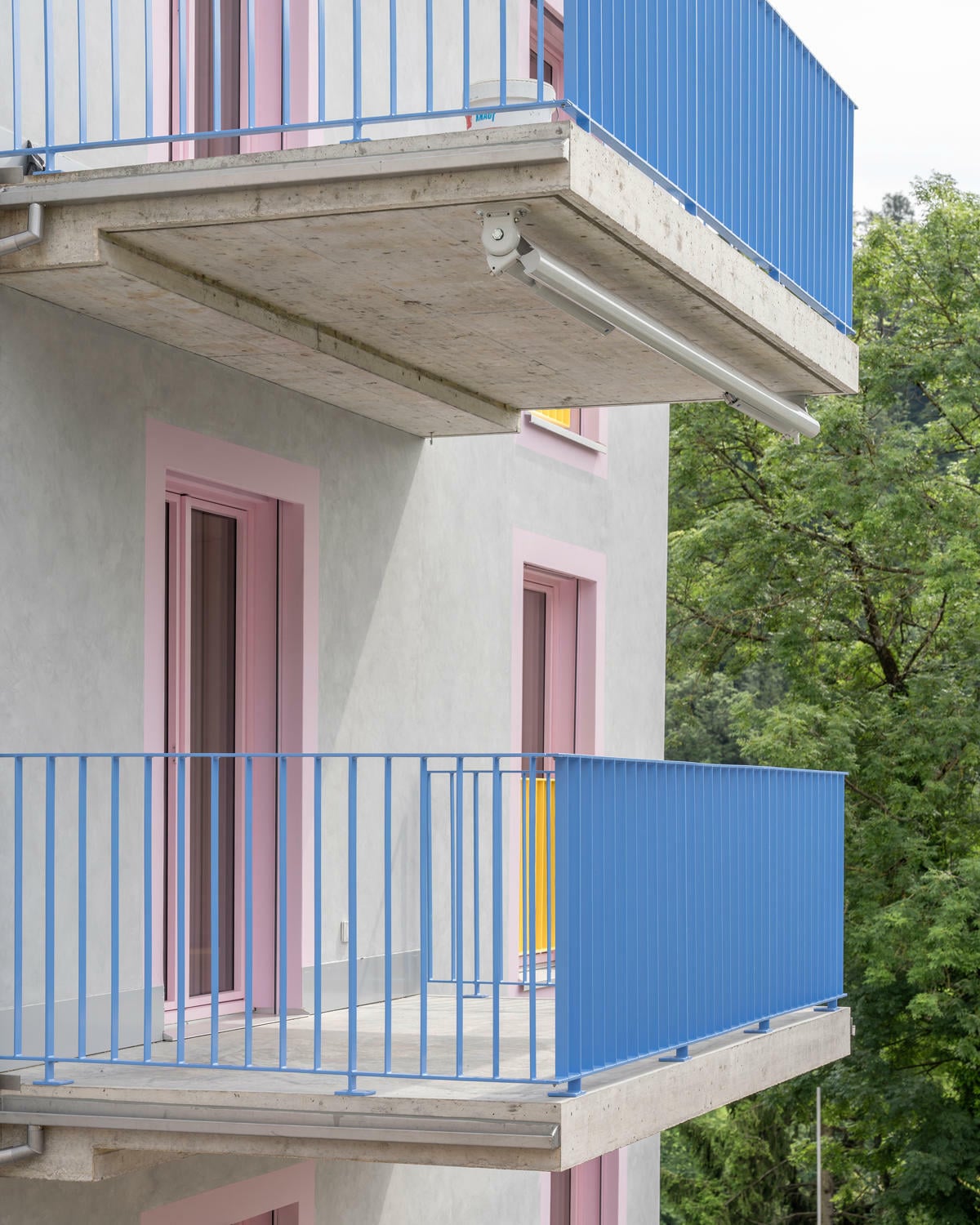 Zur Umgebung hin präsentieren sich die Bauten mit mehrfach gespachtelten und lasierten Fassaden.