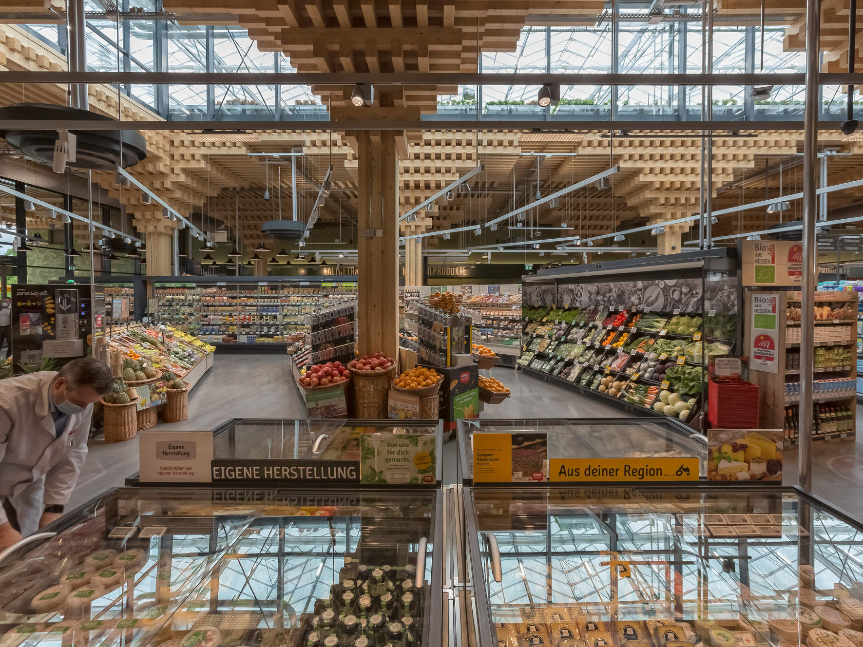 Die Einkaufshalle ist von der sichtbaren Holzkonstruktion geprägt und von Tageslicht durchdrungen.