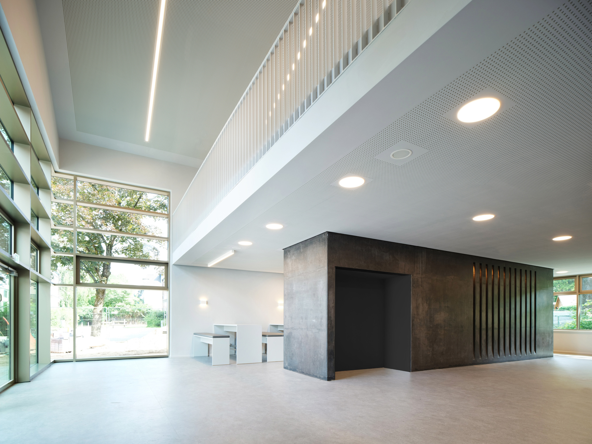 Die Mensa für die Oberstufe öffnet sich als zweigeschossiger Raum mit Galerie und großer Glasfassade direkt zum Schulhof.