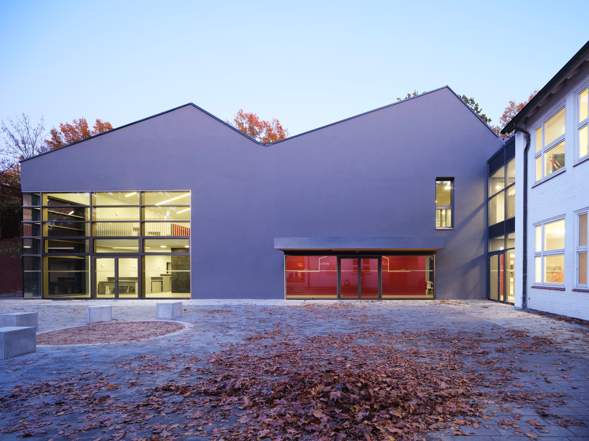 Der Neubau, der im Westen an ein bestehendes Klassenhaus (rechts im Bild) anschließt, umfasst im Inneren zwei räumlich getrennte Speisebereiche: einen für Klassen der Grundschule und einen für die weiterführenden Stufen.
