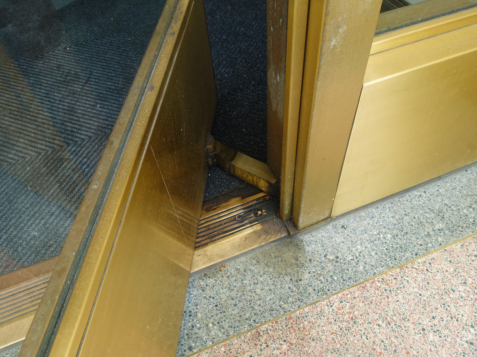 Detail einer Eingangstür mit einem gleitenden Metallbügel als Stabilisator bei erhöhten Windlasten