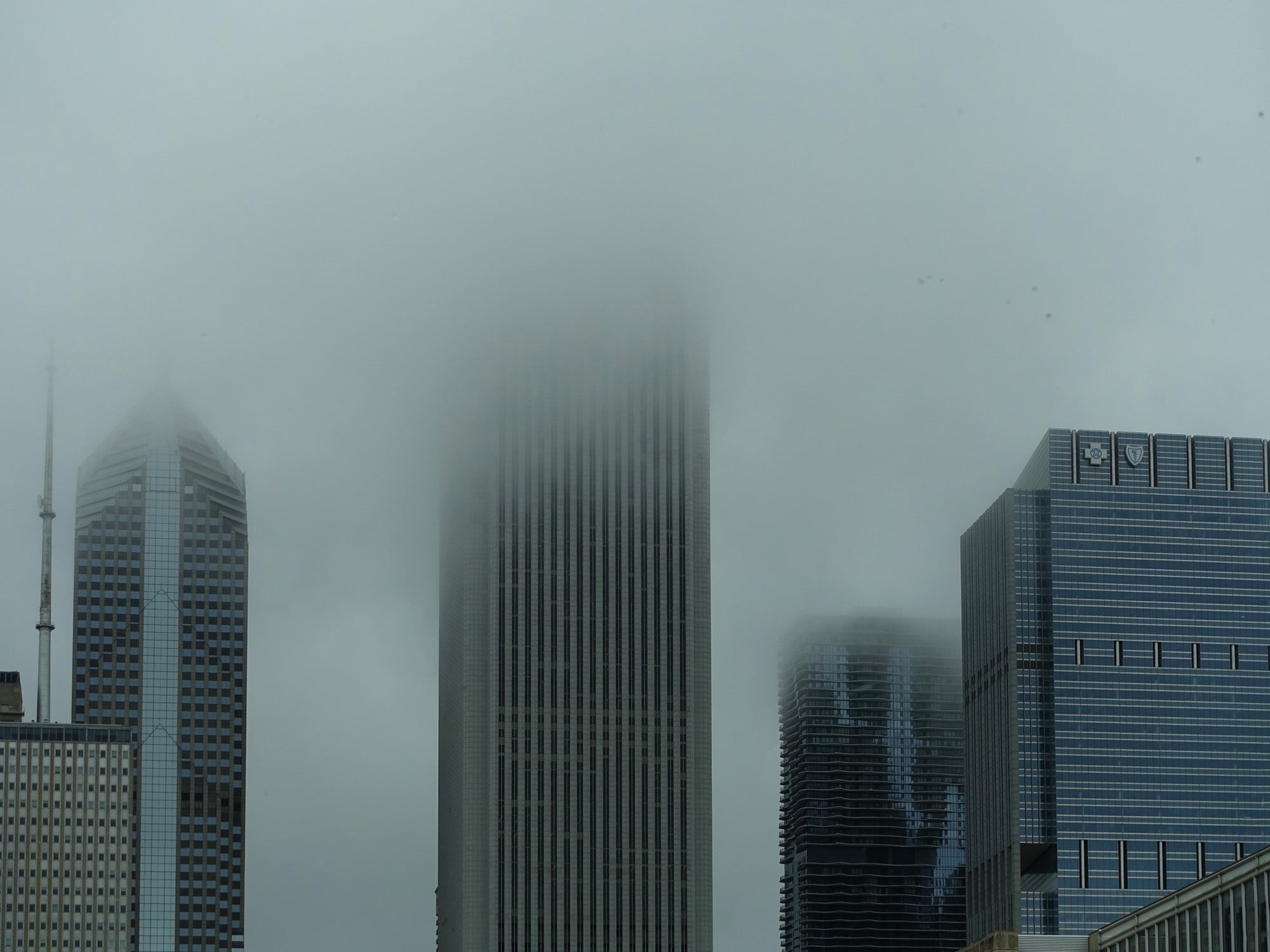 Getrübte Aussicht: Vom Lake Michigan aufsteigender Nebel hüllt die oberen Geschosse einiger Wolkenkratzer in Chicago komplett ein, im Bild das 346 m hohe Aon Center (vormals Standard Oil Building) von Edward Durell Stone, rechts dahinter der 262 m hohe Aqua Tower von Studio Jeanne Gang