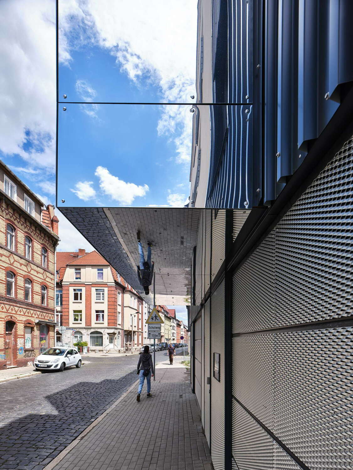Markante Erker, die mit poliertem Stahlblech verkleidet sind, spiegeln den Himmel wider.