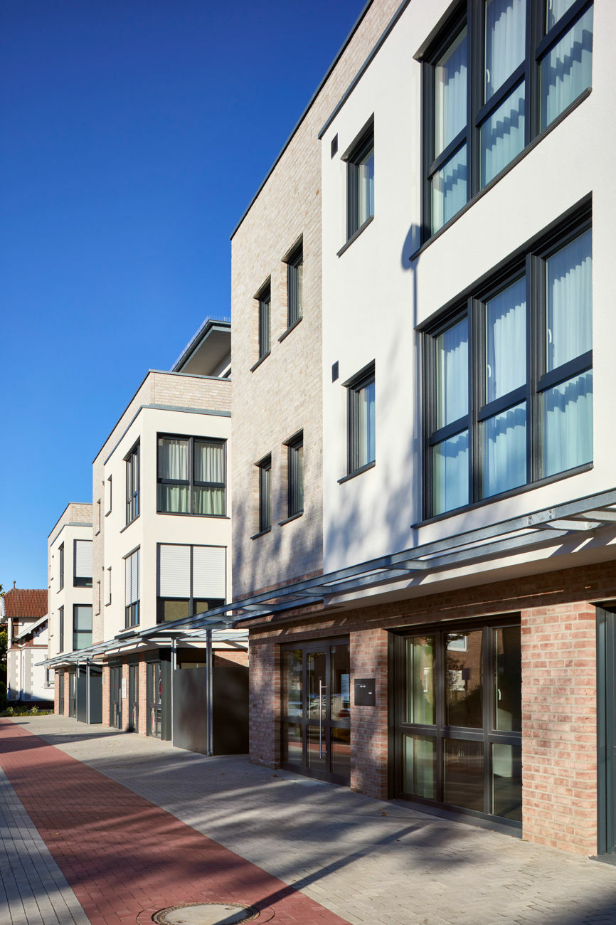 Die Architekturschaffenden wählten zur Umgebung passende Klinker – hellrote für das Sockelgeschoss und sandfarbene für die Obergeschosse – sowie weißen Putz für die auskragenden Bauteile im ersten und zweiten Stock.