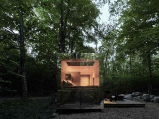 Von innen beleuchtet, erscheint das Tiny House wie ein warmer Schutzraum.