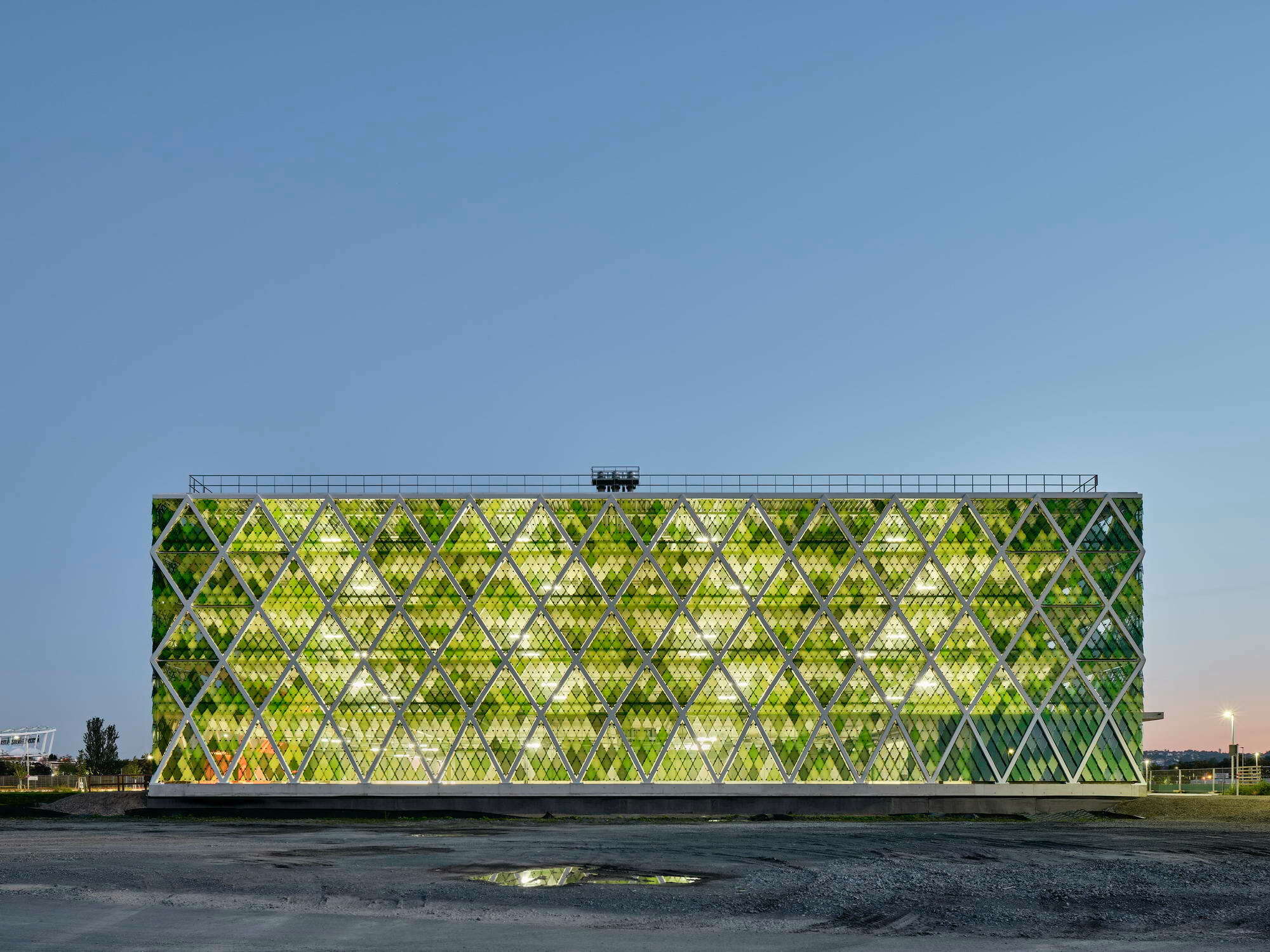 An der Nordseite hat das neue Parkhaus nach Plänen von asp Architekten im Quartier Neckarpark eine geschlossene Fassade aus rautenförmigen, in verschiedenen Grüntönen bedruckten Gläsern, um den städtischen Schallschutz zu gewährleisten.