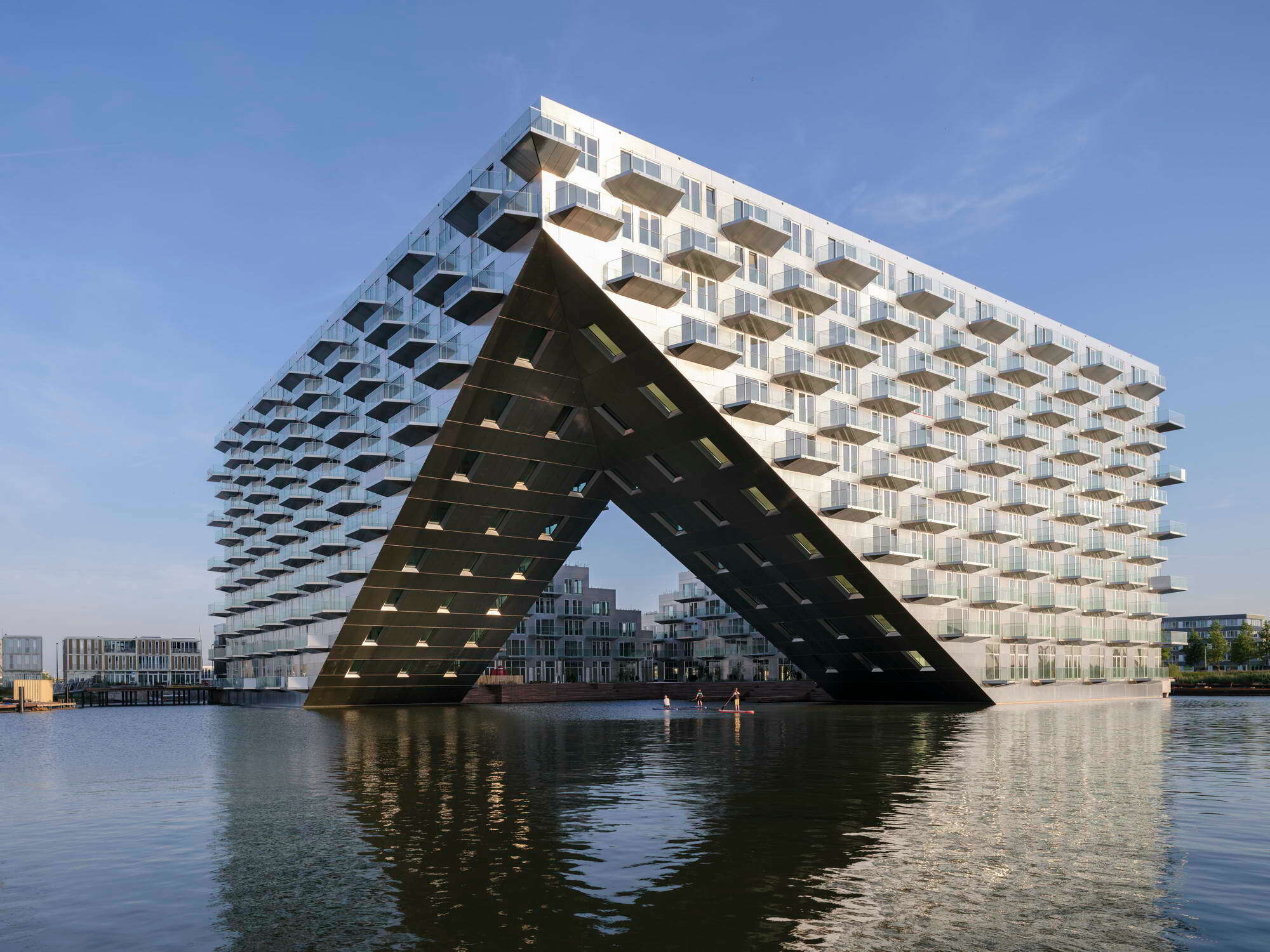 Reisende, die auf dem Wasserweg nach Amsterdam kommen, empfängt das „Sluishuis“ mit einer einladenden Geste in Form eines torartigen Einschnitts in die Kubatur.