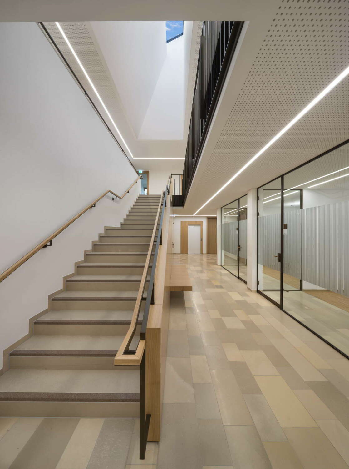 Im Erdgeschoss befinden sich die öffentlichen Ämter und Büros, teilweise hinter Glaswänden. Die Treppe erhält durch ein Oberlicht großzügig natürliches Licht.