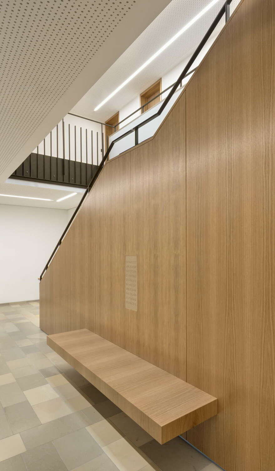 Die Treppe ins Obergeschoss mit integrierter Wartebank ist mit Eichenholz verkleidet. 