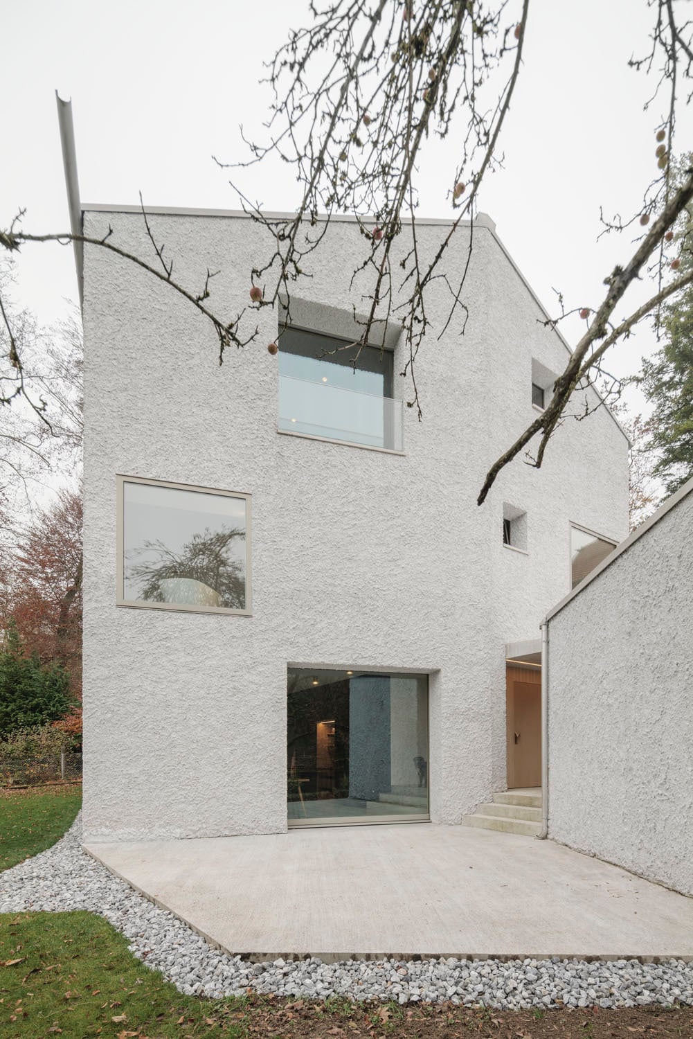 Ein schmaler Weg zwischen Wohnhaus und Garage führt zum Eingang.