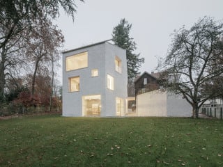 Das Einfamilienhaus in Einstein-Ziegelbauweise ohne zusätzliche Dämmstoffe, Erstlingswerk des Architekten Felix Huber, liegt zwischen zwei denkmalgeschützten Villen im bayrischen Voralpenland.