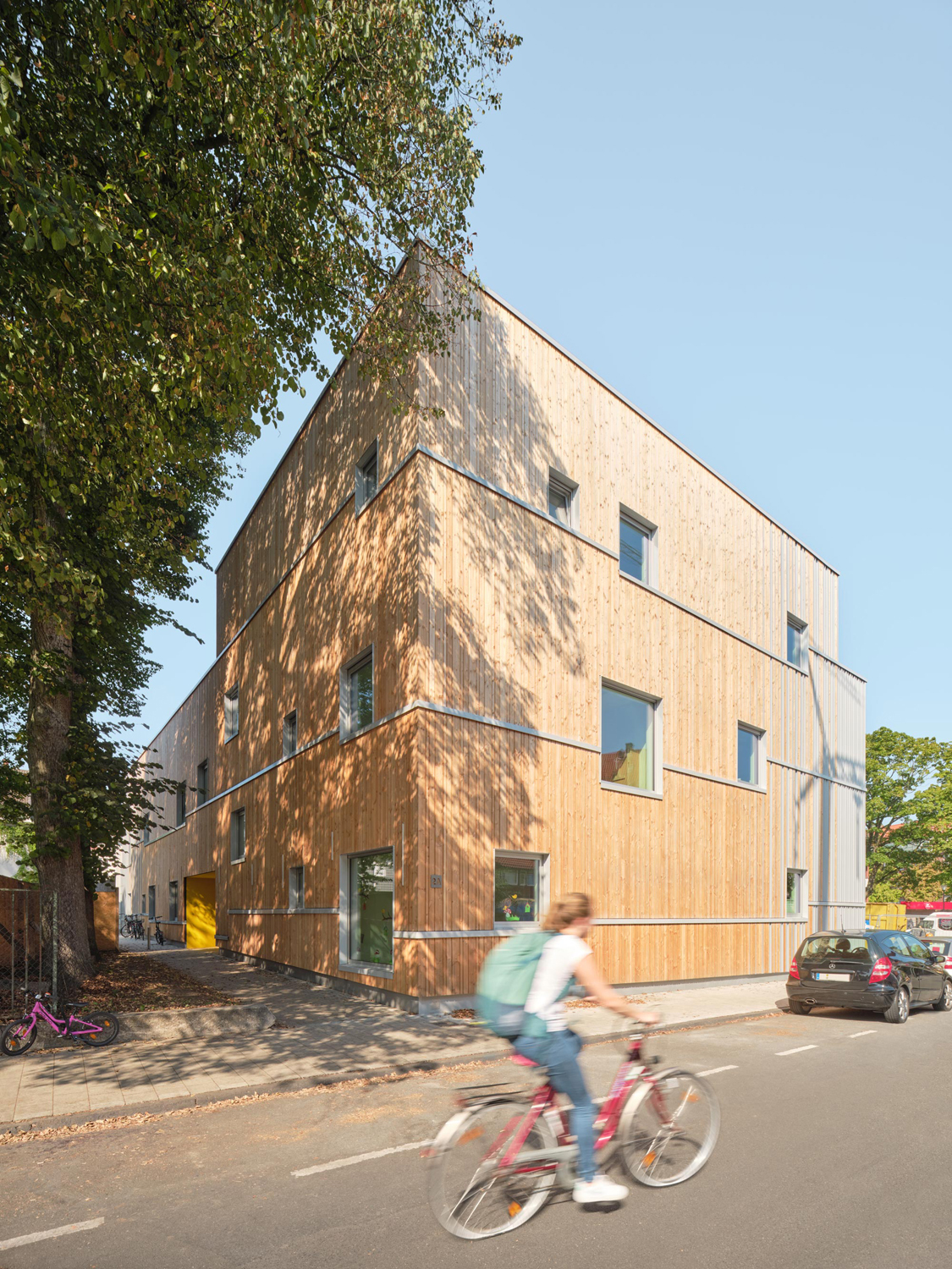 Die Kindertagesstätte wurde als Niedrigenergiehaus in Holzhybrid-Bauweise errichtet – als Kombination eines punktgestützten Stahlbetontragwerks mit einer nichttragenden, vorgefertigten Holztafelbau-Gebäudehülle aus regionaler Douglasie.