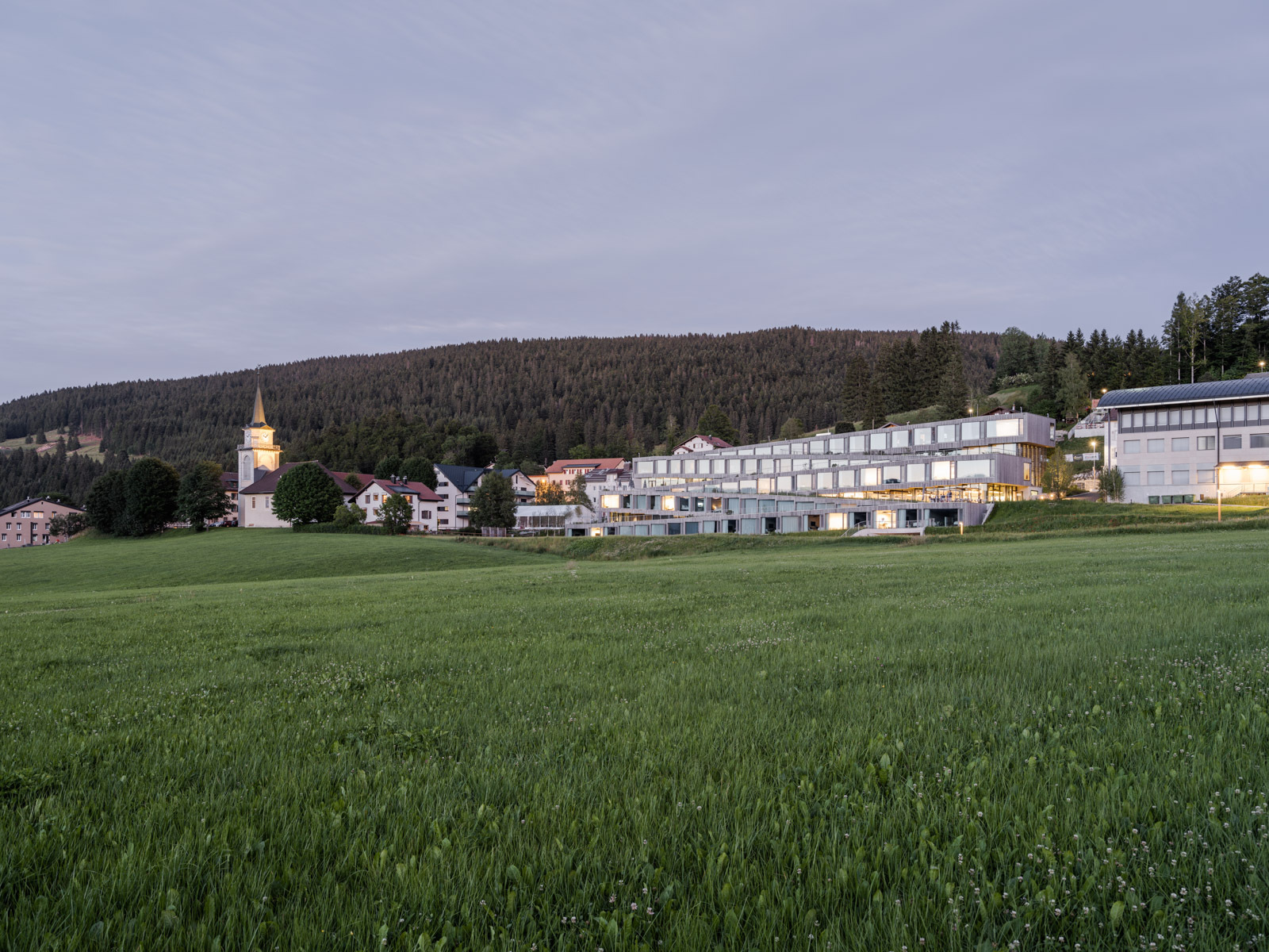 Vom Straßenniveau aus schlängelt sich das ungewöhnliche Hotel mit markanter Holz-Glas-Fassade sanft im Zickzack das Tal hinab.