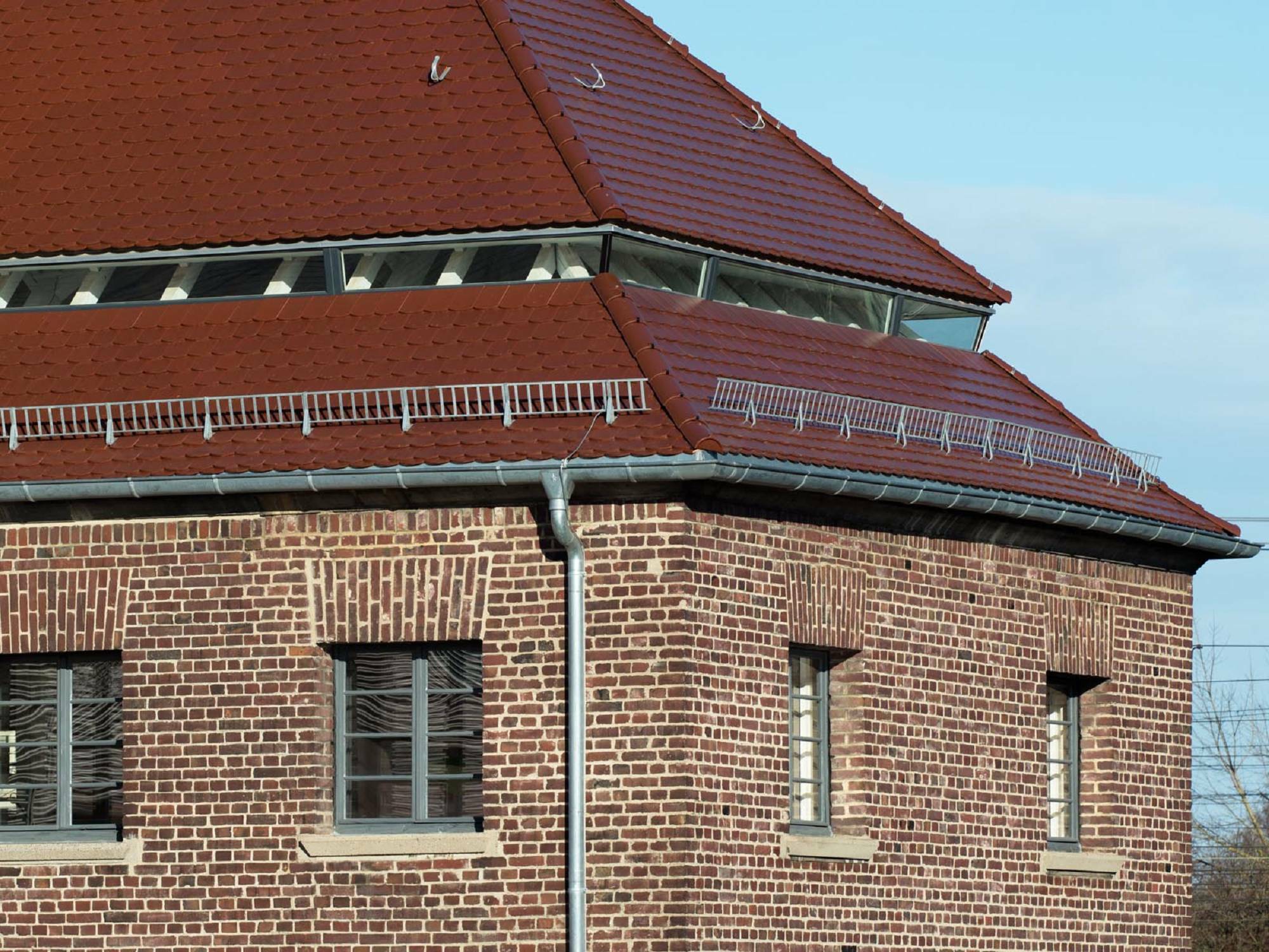 Der Seitenflügel verfügen über Walmdächer mit einem schmalen Fensterband, das im Zuge der Nachdämmung entstand.