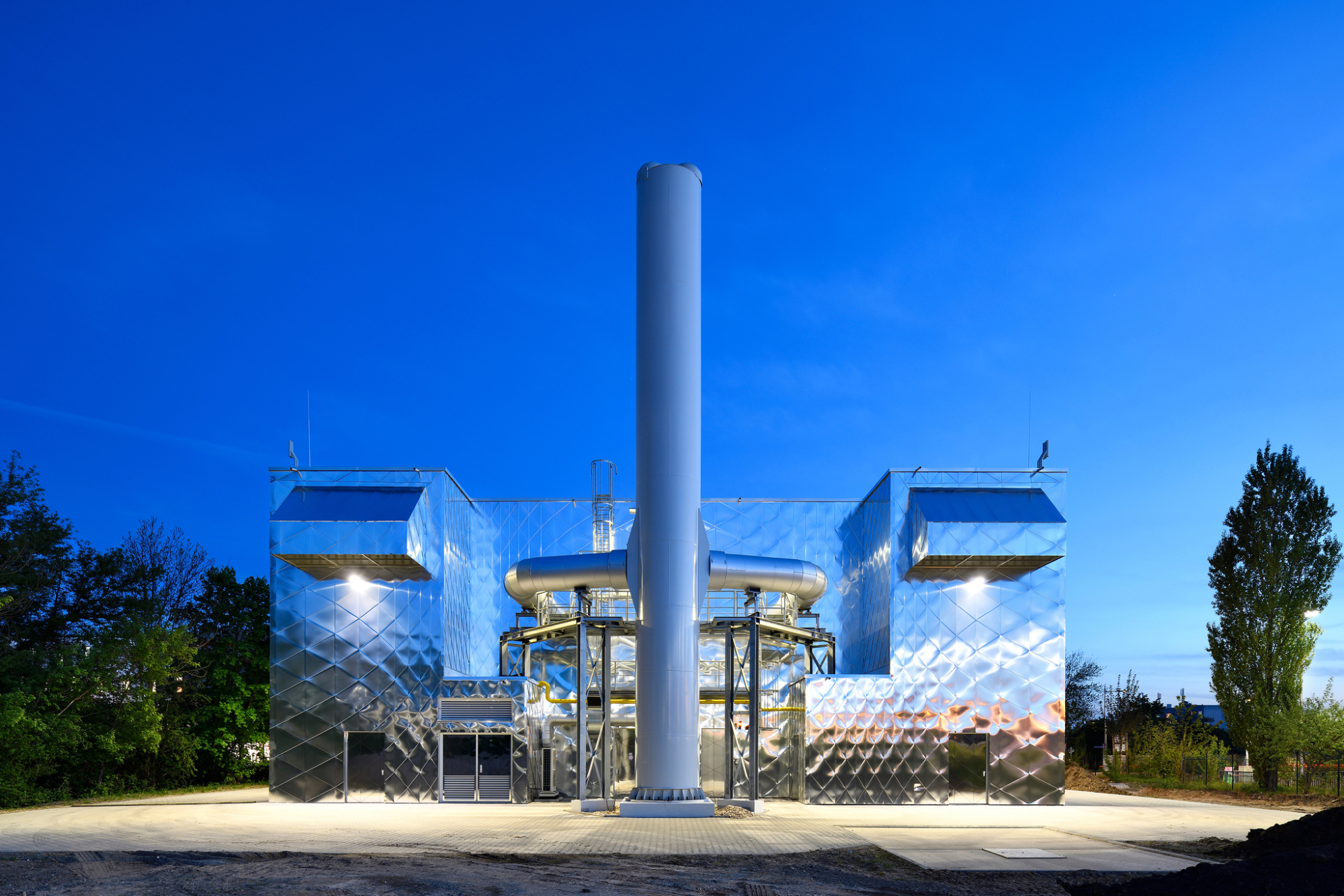 Errichtet nach einem Entwurf von Thoma Architekten aus Berlin, gibt sich das Blockheizkraftwerk über seine Kubatur zu erkennen. Die schimmernd spiegelnde Fassadenbekleidung bindet es in den städtebaulichen Zusammenhang ein.