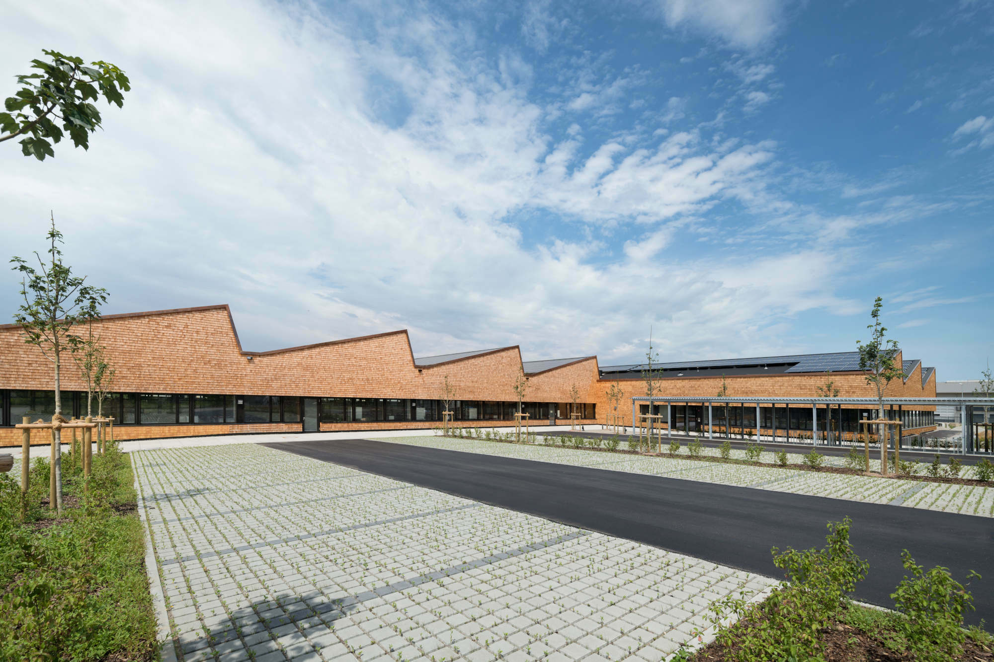 Zwei Hallen ergänzen den Bestand und rahmen die Freifläche mit Parkplätzen. 