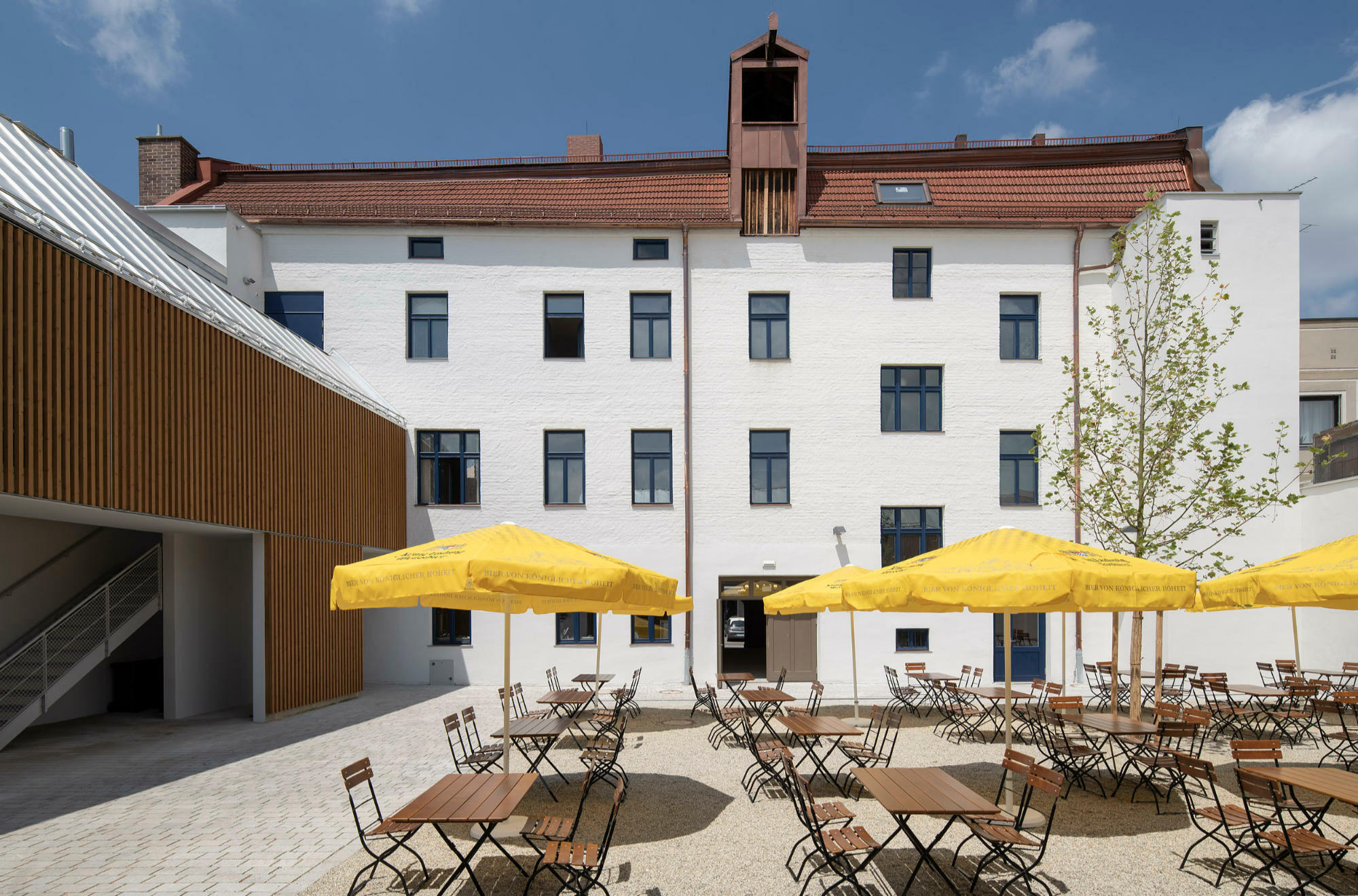 Der neue Biergarten wird gefasst durch das Bestandsgebäude und einen Technik-Anbau mit offener Fluchttreppe.