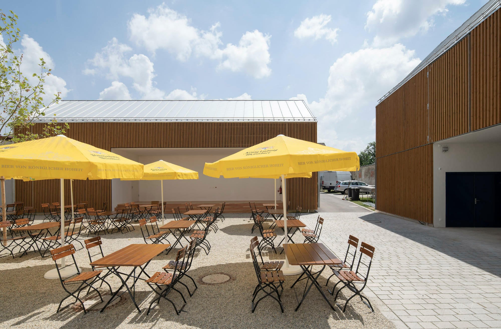 Ein weiterer Neubau in Holzbauweise (genannt Holzstadel) beherbergt Lagerflächen, aber auch eine Freilichtbühne, die dem Biergarten zugewandt ist.