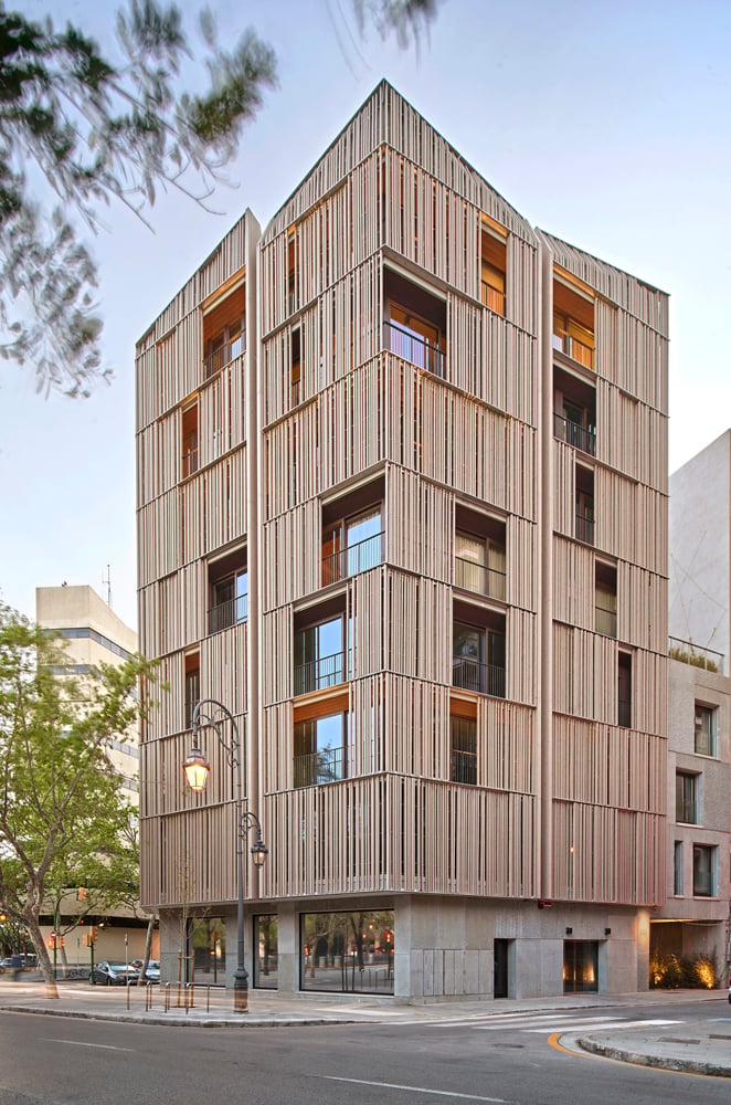 Betonfertigteile, raumhohe Verglasung und vorgesetzte Holzlamellen bilden die Fassade.