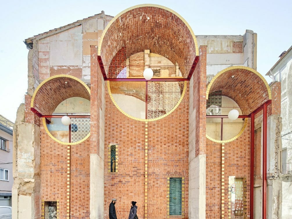Für die durch Abriss sichtbar gewordene Brandwand mit den Spuren der vorherigen Wohnungen entwarf das ortsansässige Architekturbüro Unparalld'Arquitectes eine Gewölbestruktur aus roten Hohlziegeln.