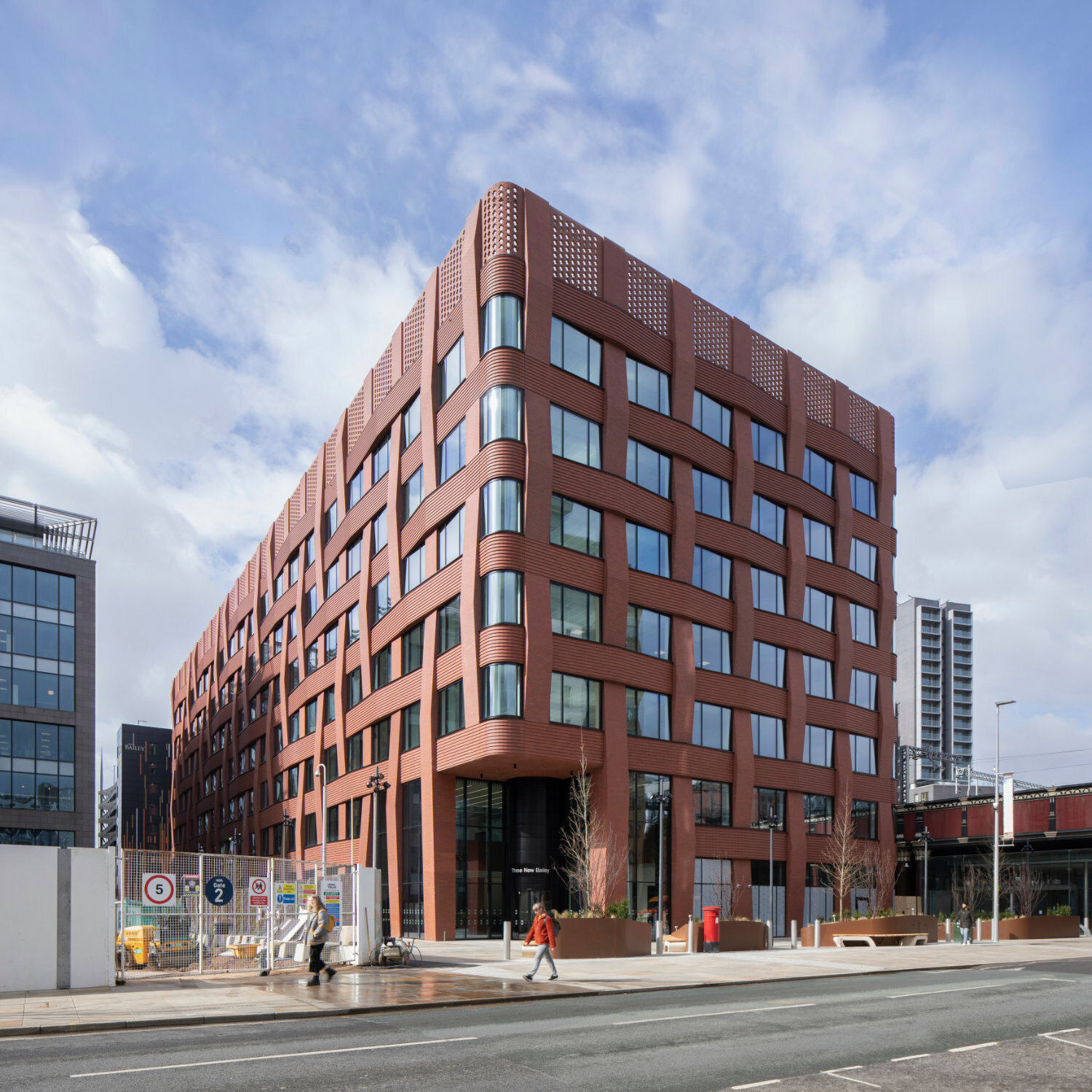 Mit Hilfe von vorgefertigten Ziegelelementen imitiert die Fassade das Gewebe von Textilien – ein Verweis auf die Geschichte der Stadt.