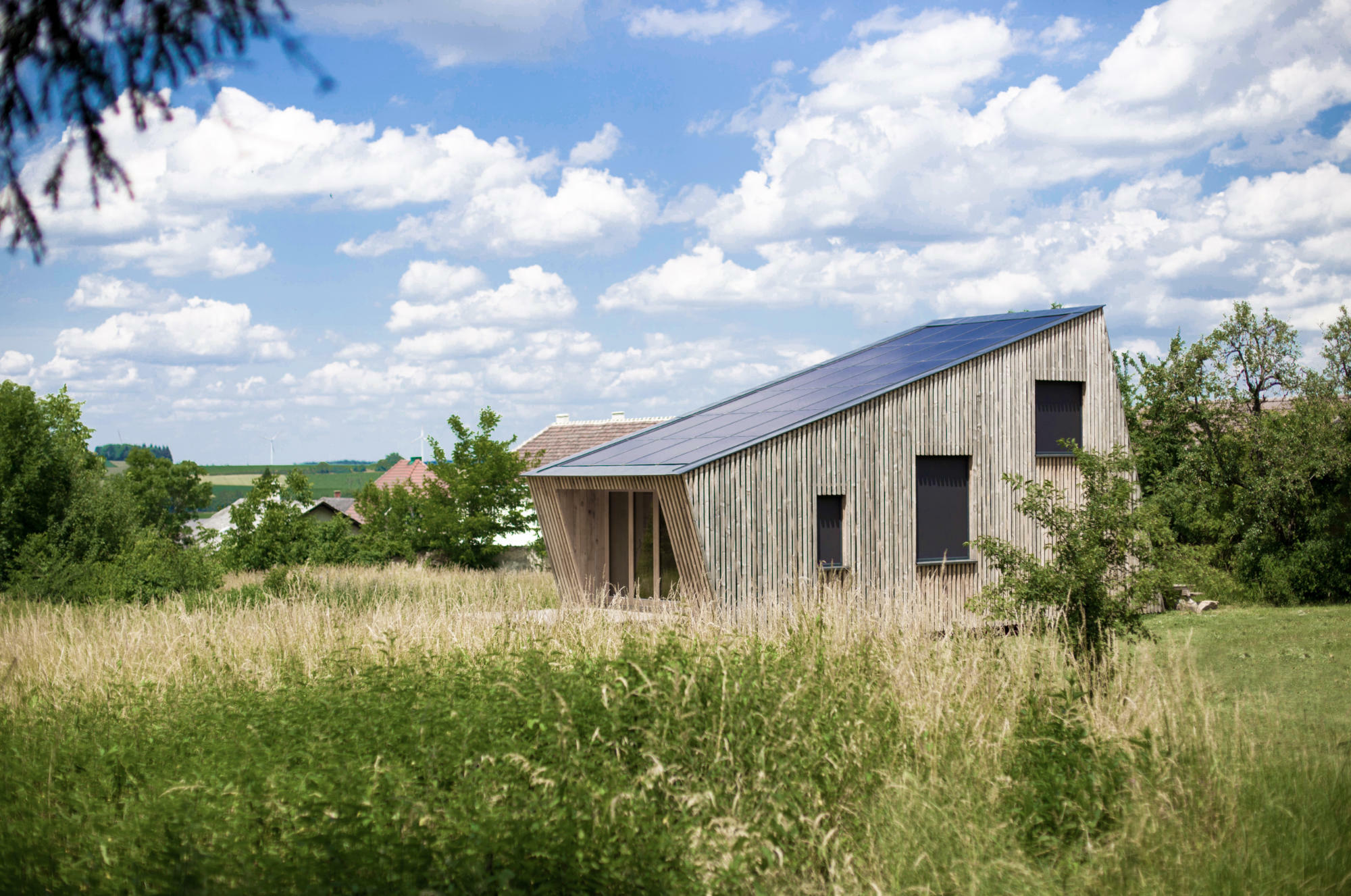 ein aufgeständertes Wochenendhaus aus Holzriegelbauweise mit Strohballendämmung und PV-Anlage.
