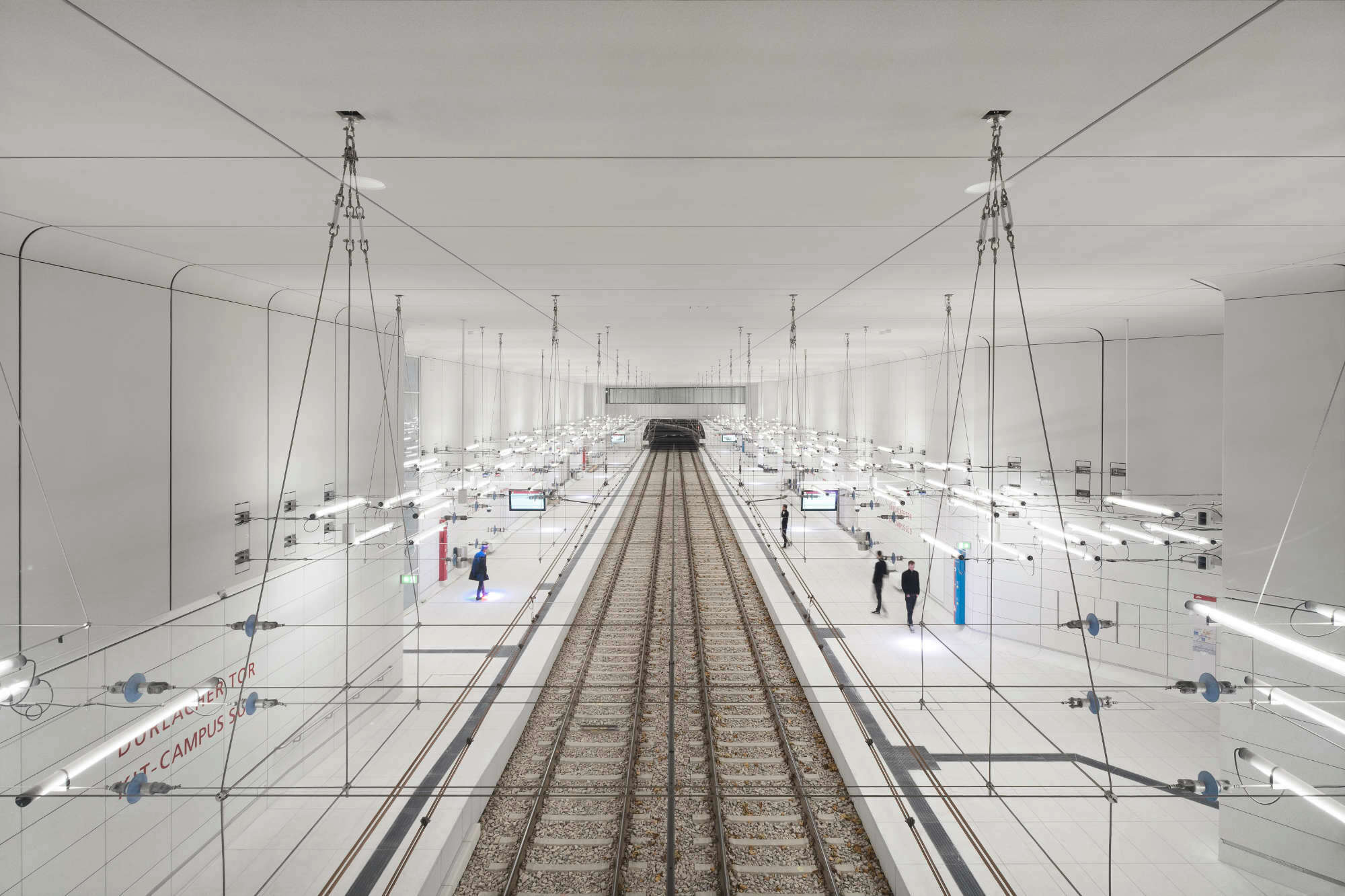 Weiße Raumschalen bekleiden die Bahnsteigbereiche allseitig, wobei die Übergänge zwischen Boden, Wand und Decke abgerundet sind. 