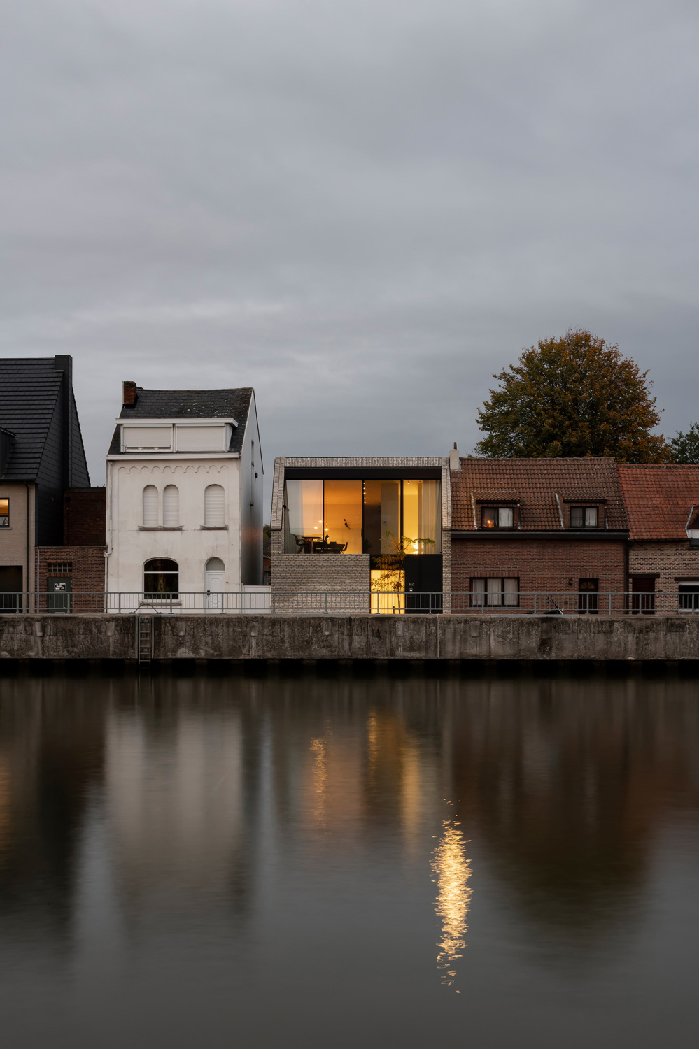 Der Ersatzneubau mit Wasserblick reiht sich in die kleinteilige Bebauung aus zwei- bis dreigeschossigen traufständigen Wohnhäusern ein.
