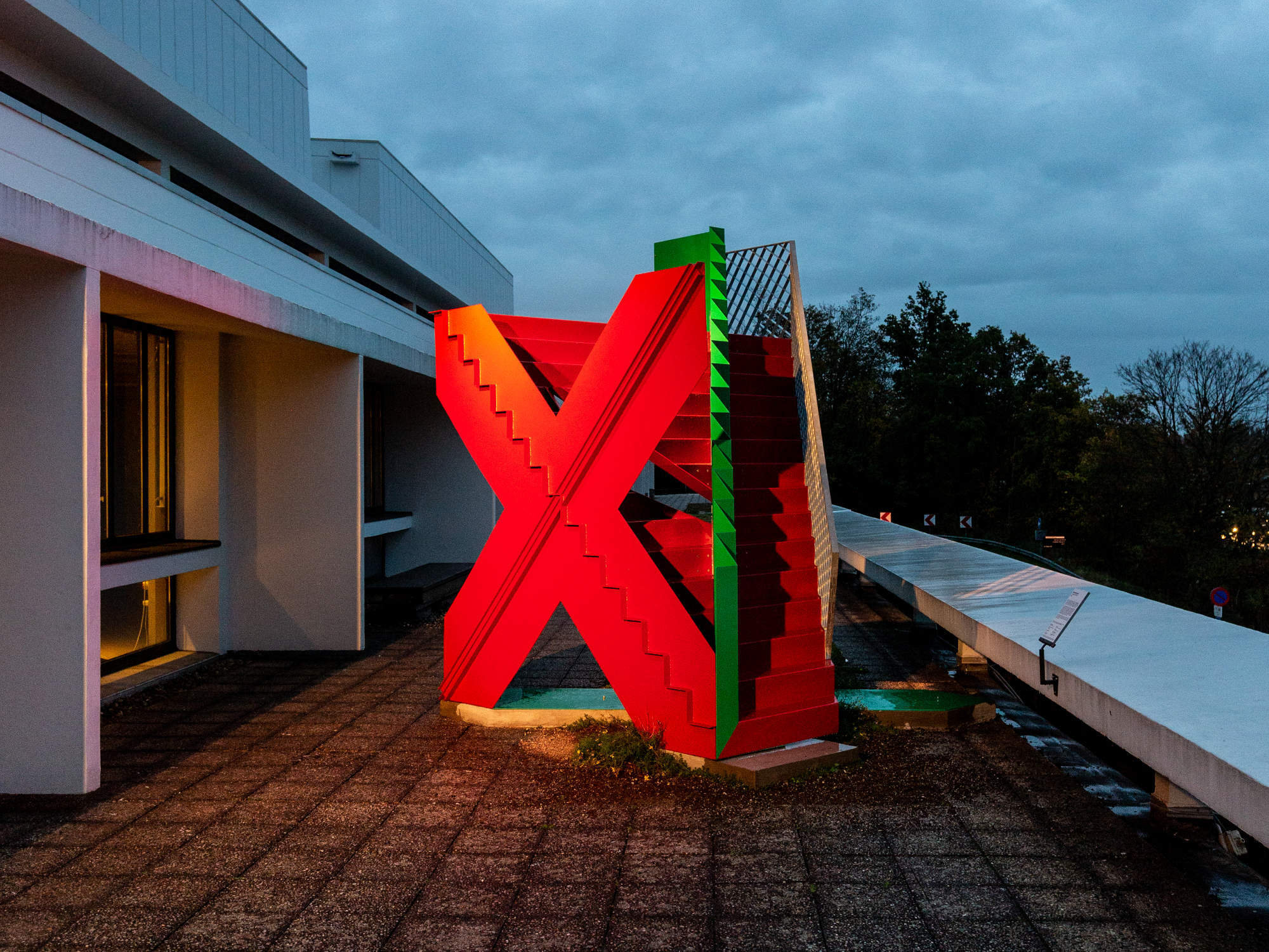 Eine rotgrüne, begehbare Treppenskultur aus Stahl thront auf der Terrasse des Antwerpener Kunstzentrums De Singel.